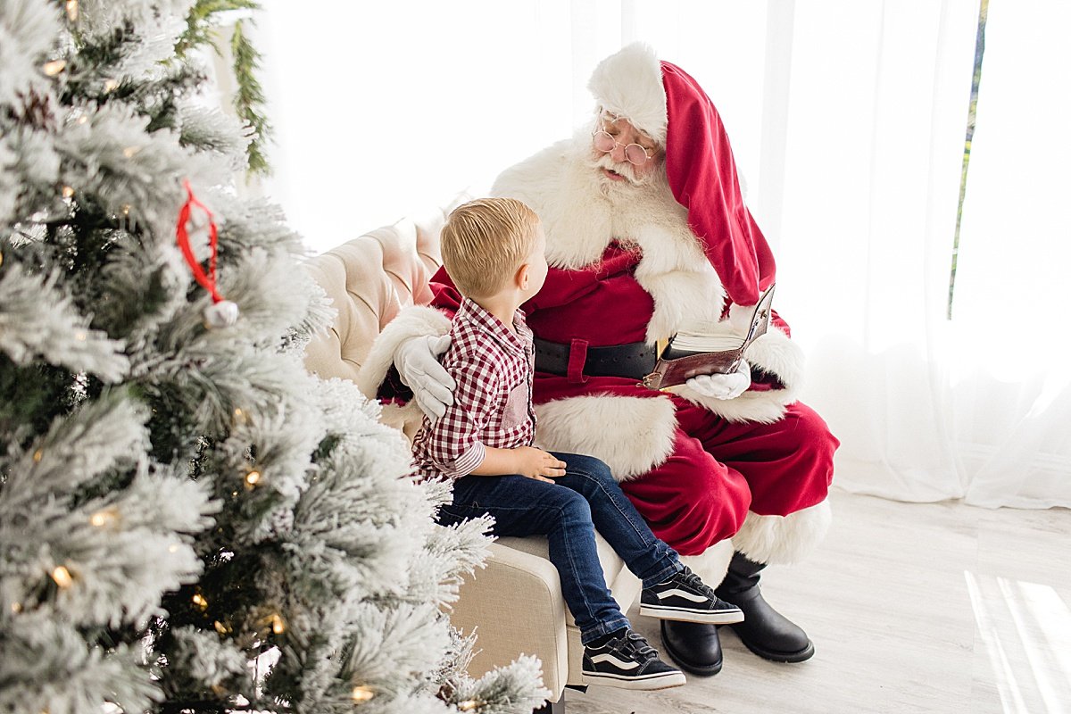 Santa talking to boy during Santa's Magical Experience with Ambre Williams Photography in Newport Beach studio | Magical Holiday Winter Mini Session