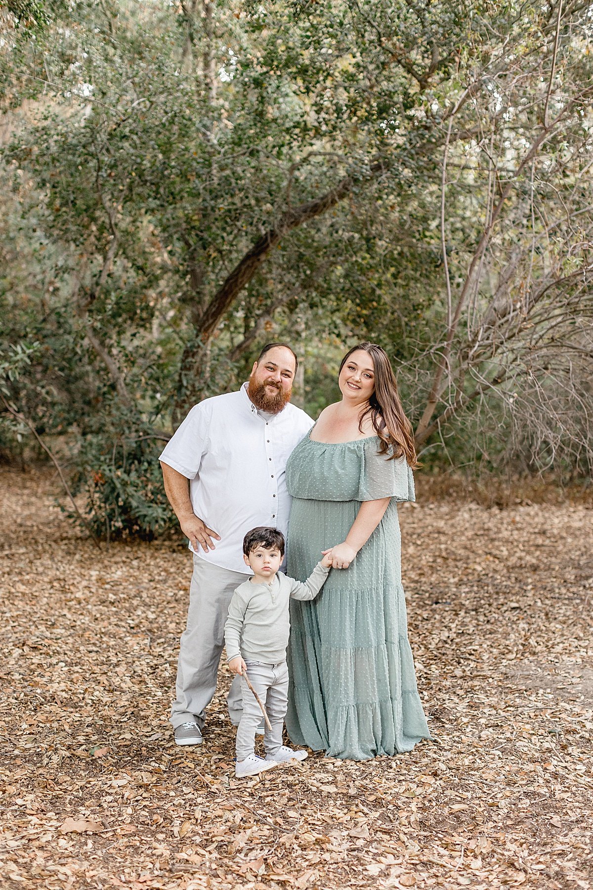 Small family portrait during fall. Outdoor forest photoshoot with family of three. Ambre Williams Photography, CA photographer, takes photographs of family together