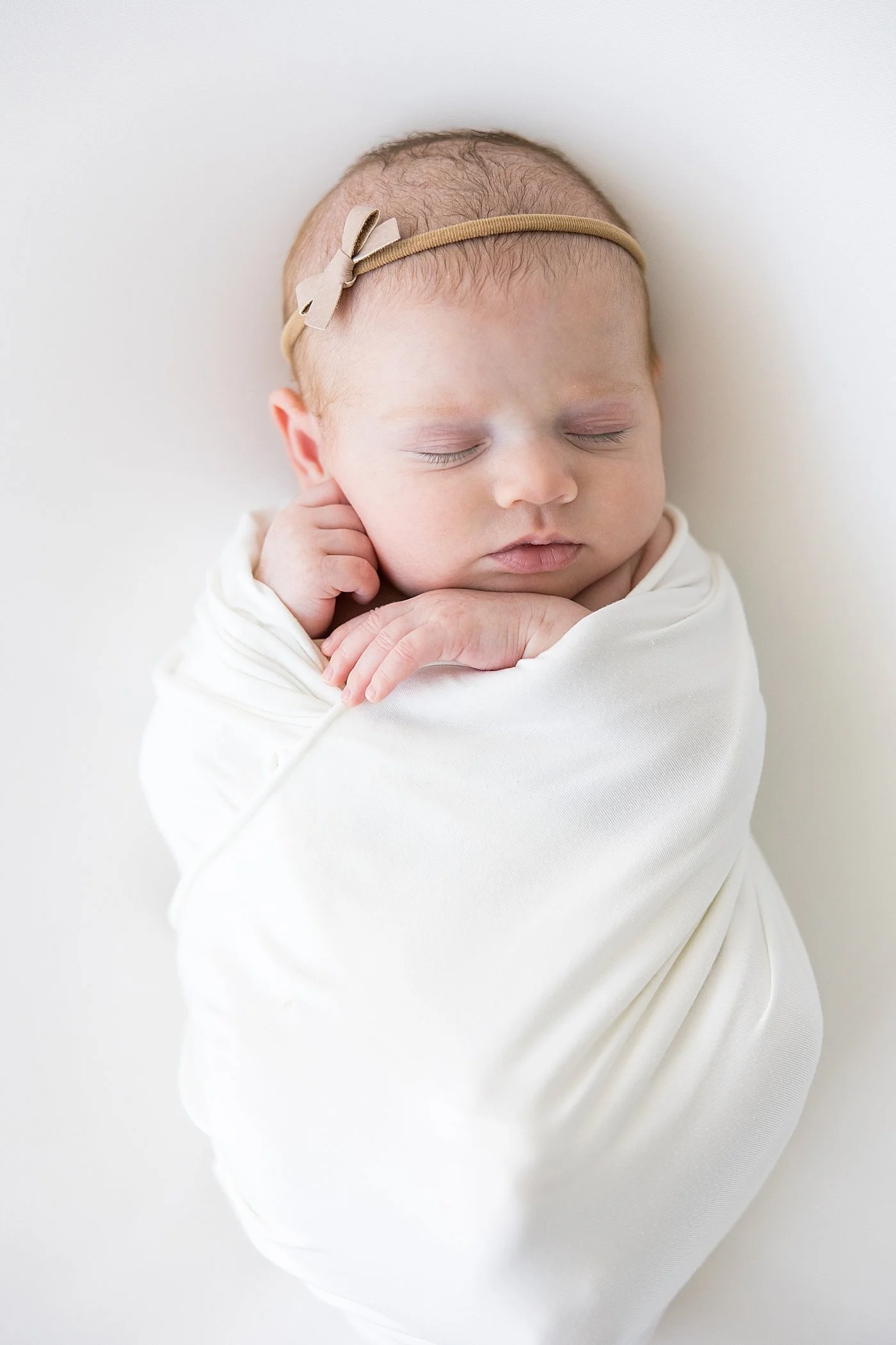 Newborn Baby Girl in White Swaddle | Ambre Williams Photography