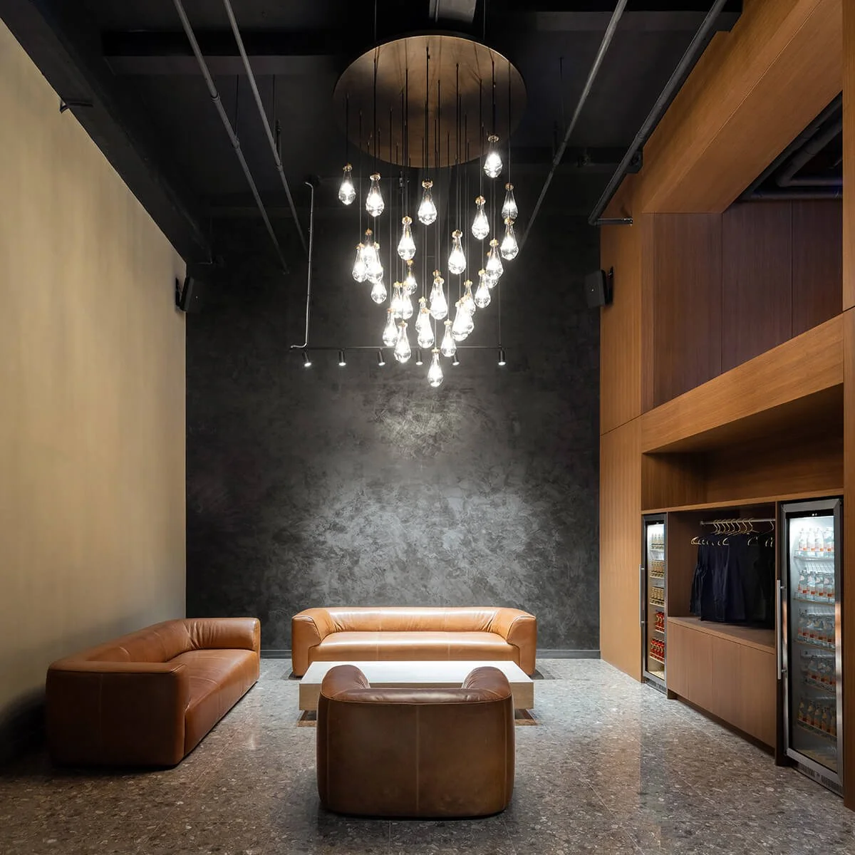 Lounge area with leather sofas and glass chandelier at TMPL Madison NYC