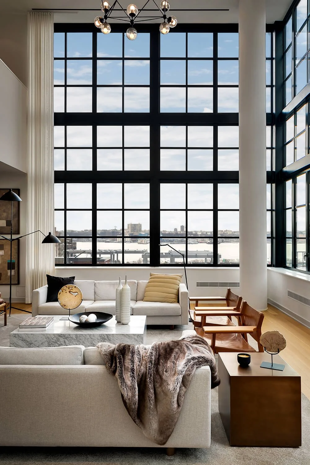 Luxury living room in Hudson Yards New York City with floor-to-ceiling steel windows overlooking the Hudson River, photographed by Brian Berkowitz Photography