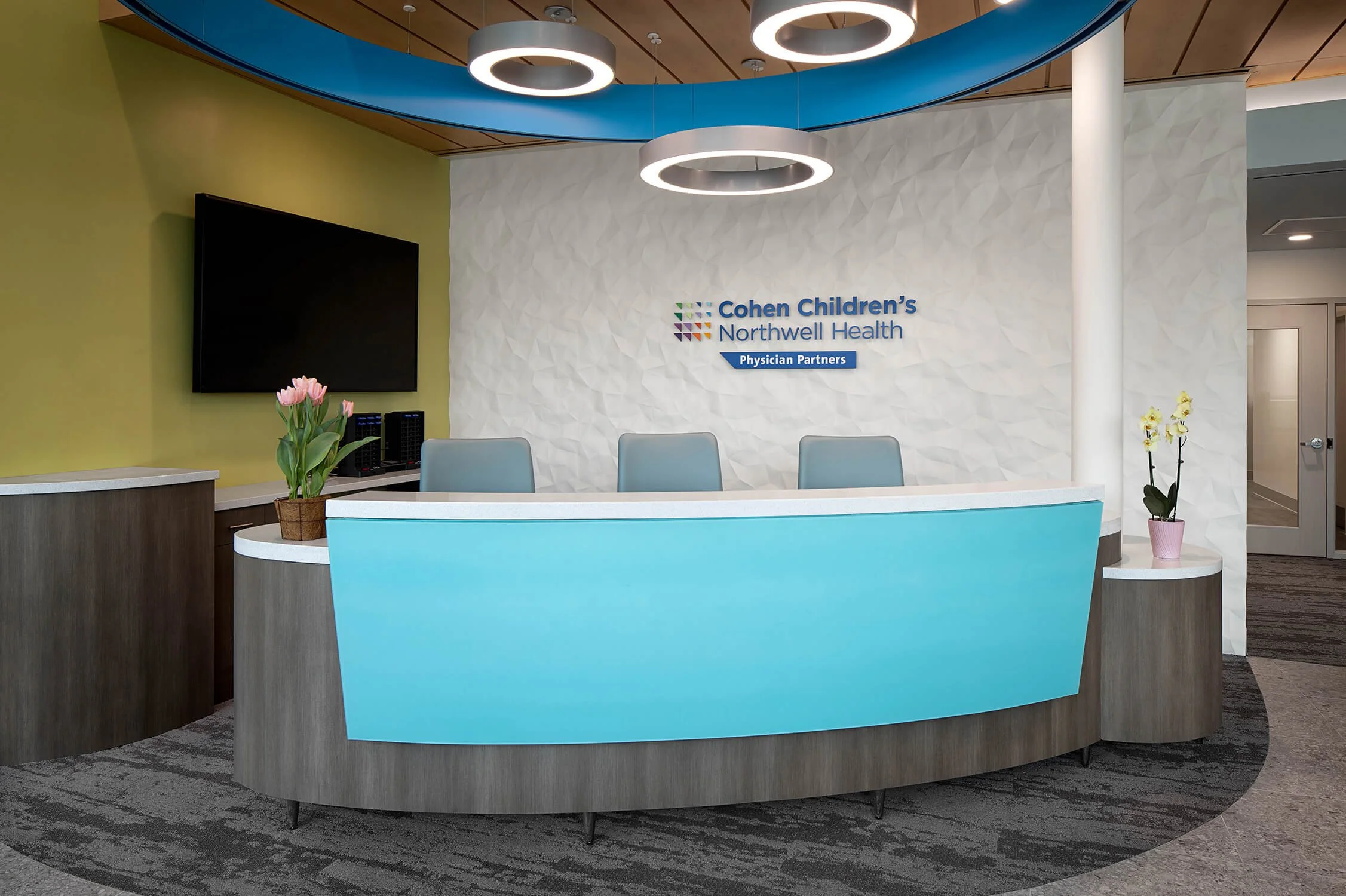 Cohen Children's Northwell Health curved blue reception desk and waiting area, healthcare interior photography by Brian Berkowitz Photography New York