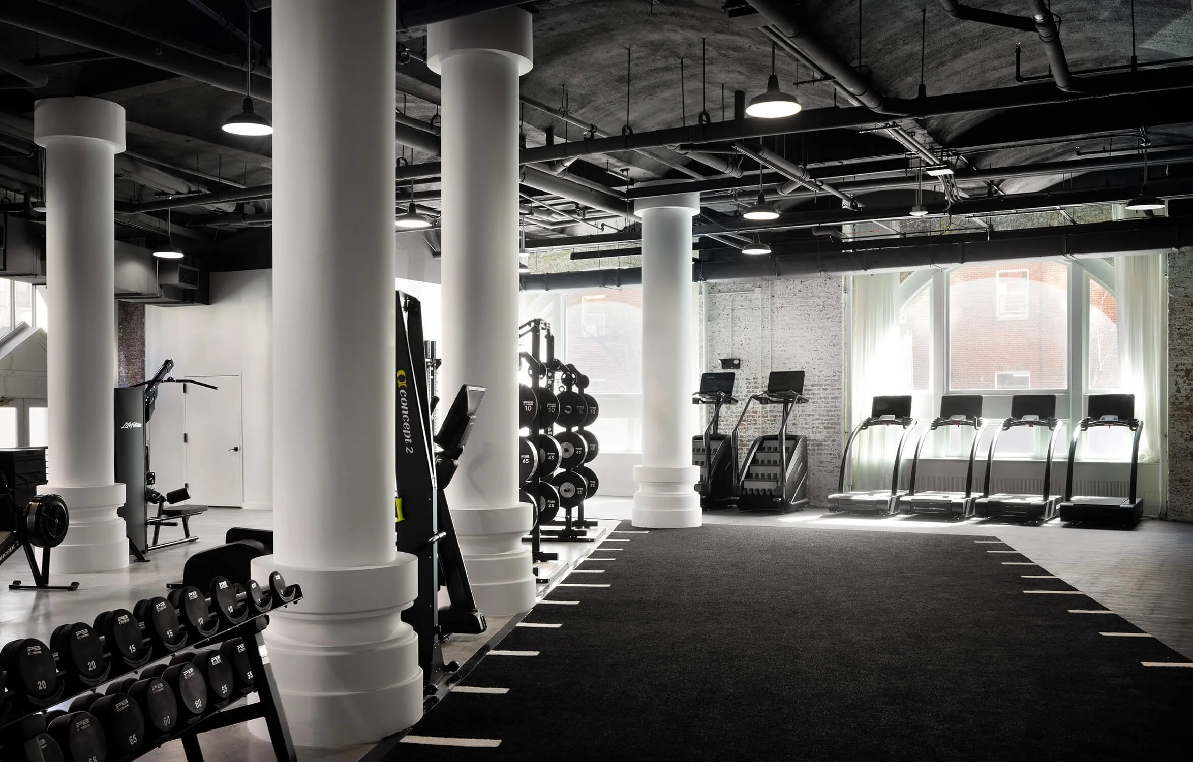 Minimalist wellness gym with natural light and modern equipment by Long Island Interior Design Photography
