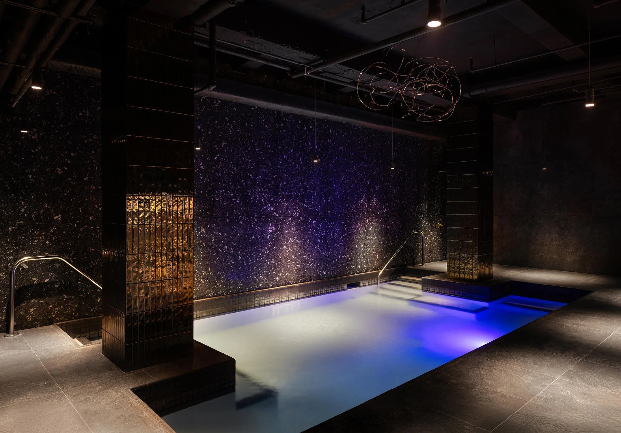 Luxury indoor spa pool with dramatic lighting by NYC Architectural Photography.