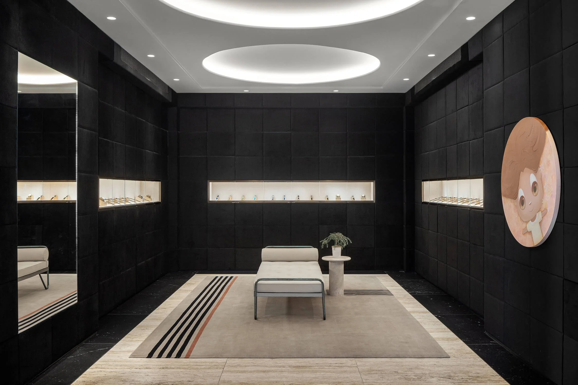 Dramatic black jewelry showroom with illuminated display cases, oval ceiling light and daybed, 1916 Company NYC, Brian Berkowitz Photography