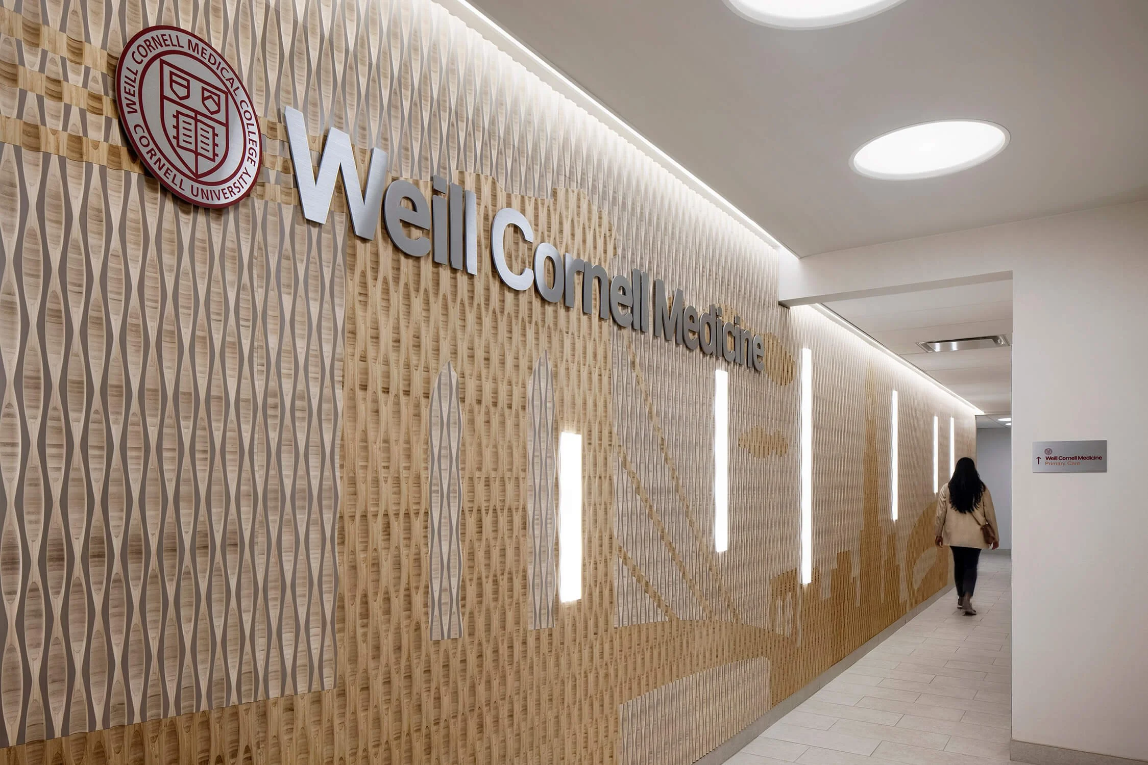 Weill Cornell Medicine branded corridor wall with textured panels and illuminated logo, healthcare photography by Brian Berkowitz Photography NYC