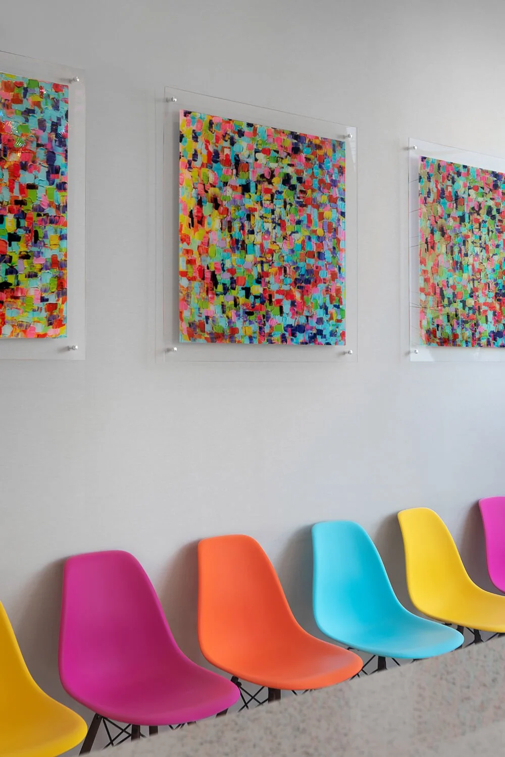 Pediatric dental office waiting room with colorful Eames chairs and abstract art wall, healthcare photography by Brian Berkowitz Photography New York