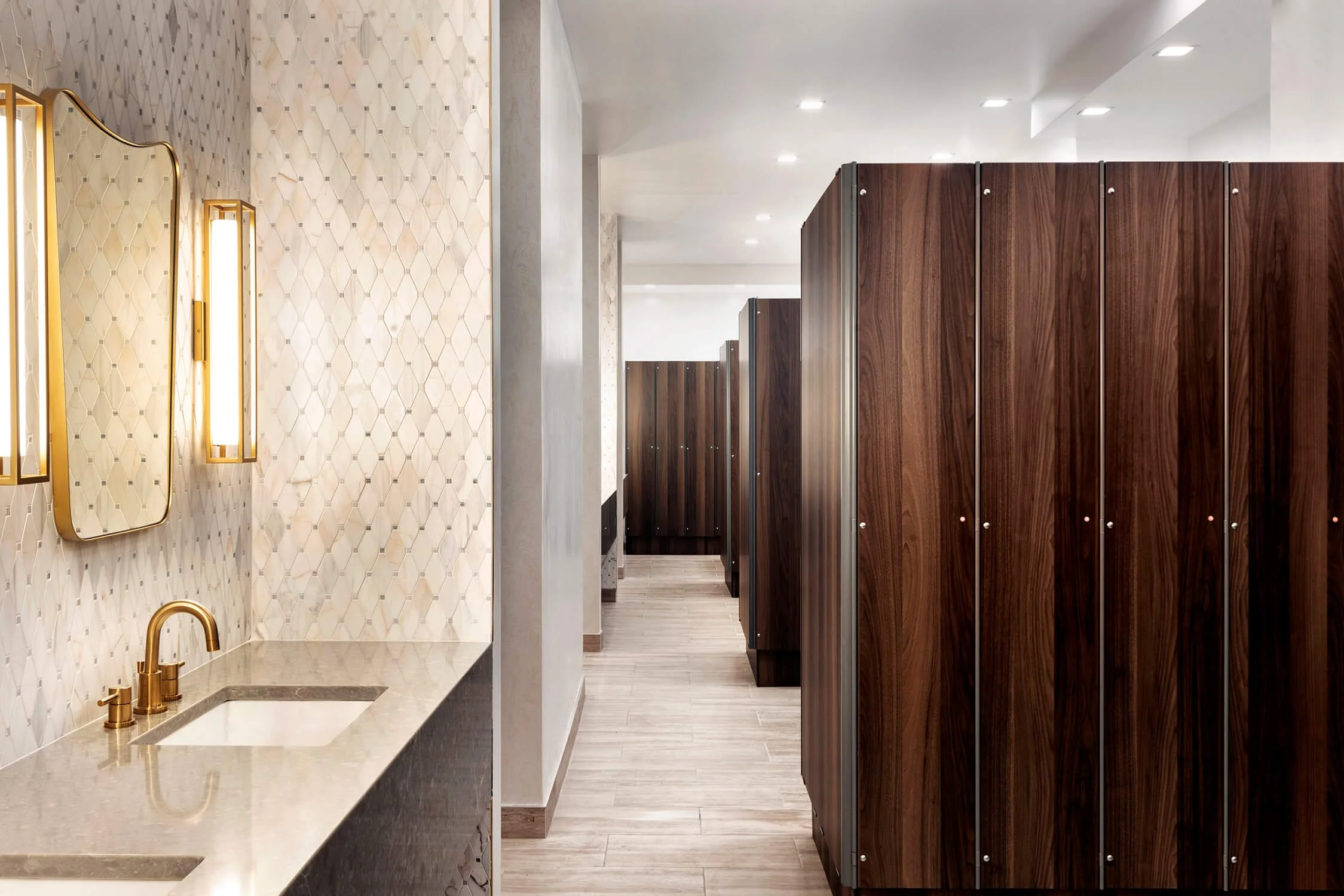 Elegant spa locker room with wood cabinetry and gold fixtures by Interior Design Photographer NYC.