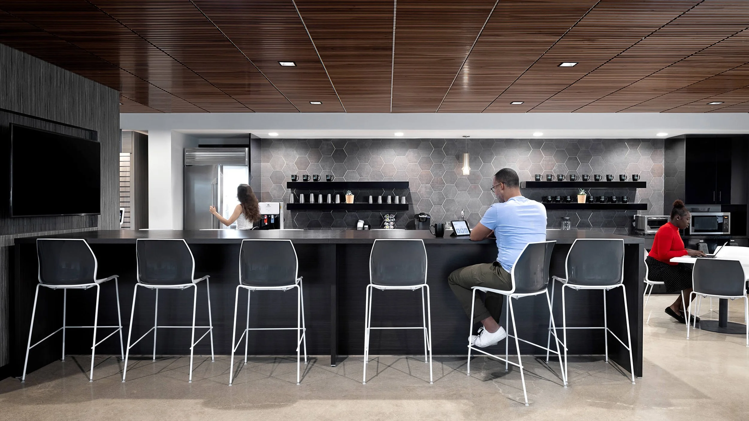 Corporate café bar with hexagonal tile backsplash, wood ceiling and pendant lighting, commercial interior photography by Brian Berkowitz