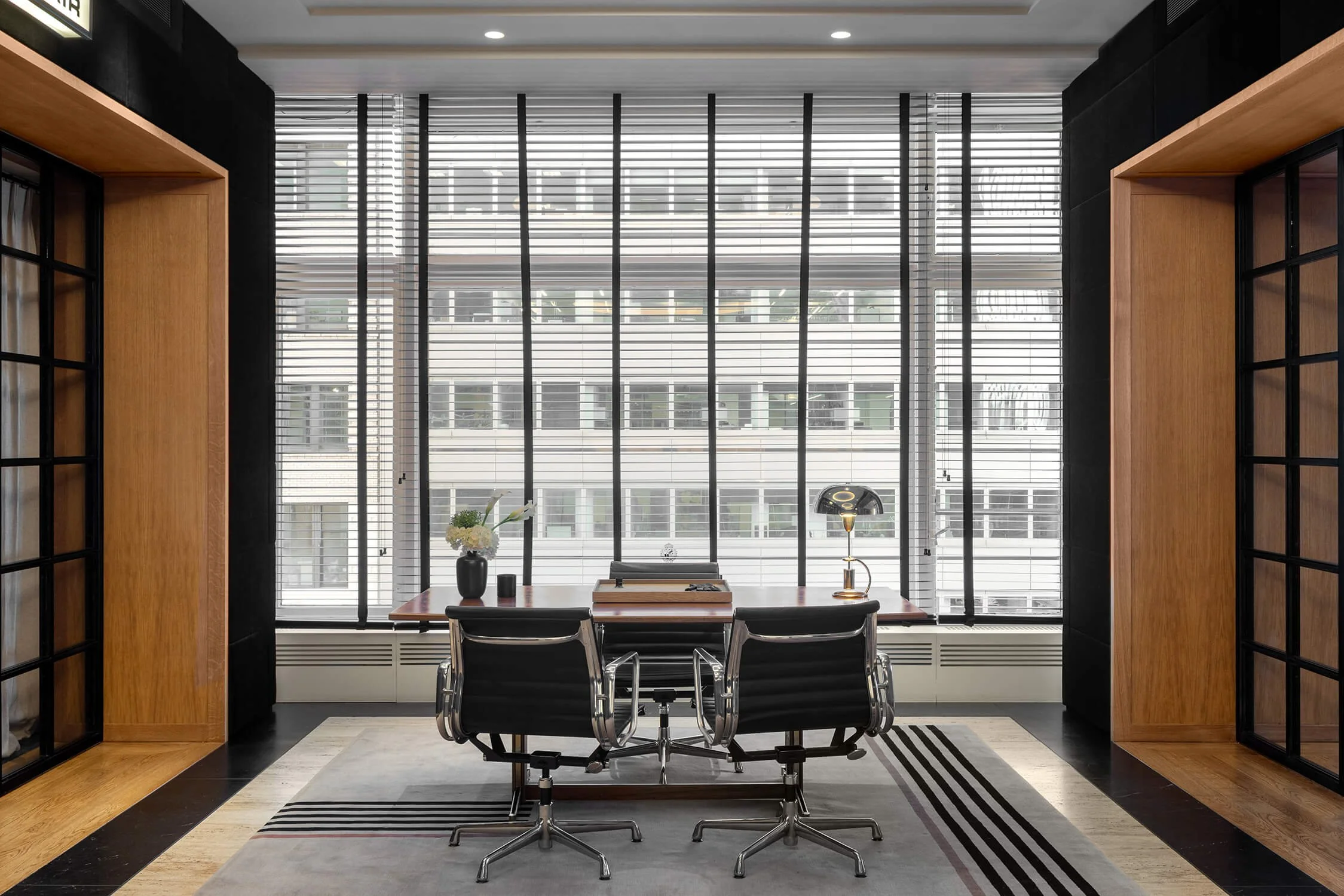 Corporate office with Manhattan skyline viewed through steel door frames and Eames chairs, 1916 Company NYC, Brian Berkowitz Photography