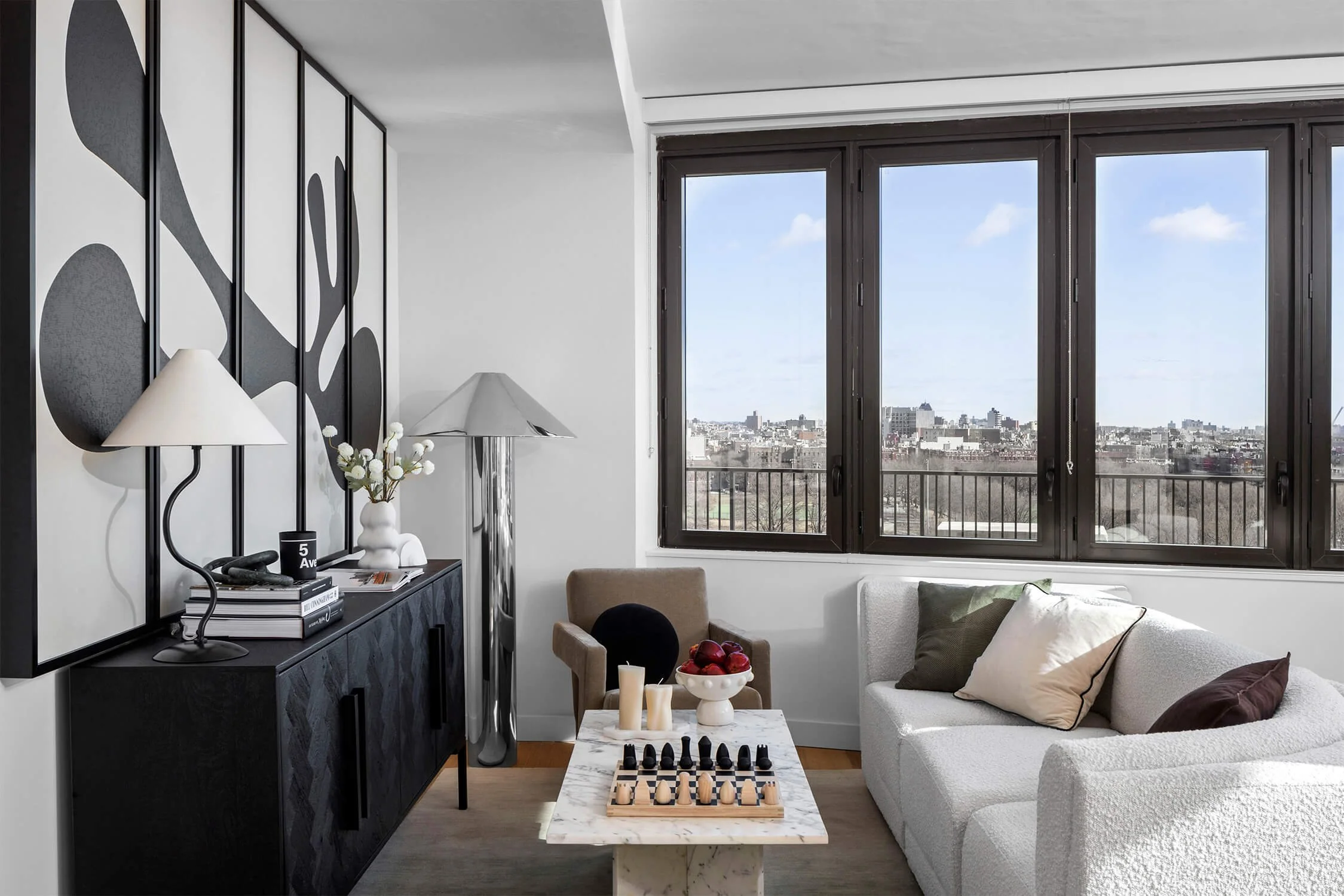 Contemporary living room with large black-and-white wall art, city views, and cozy seating.