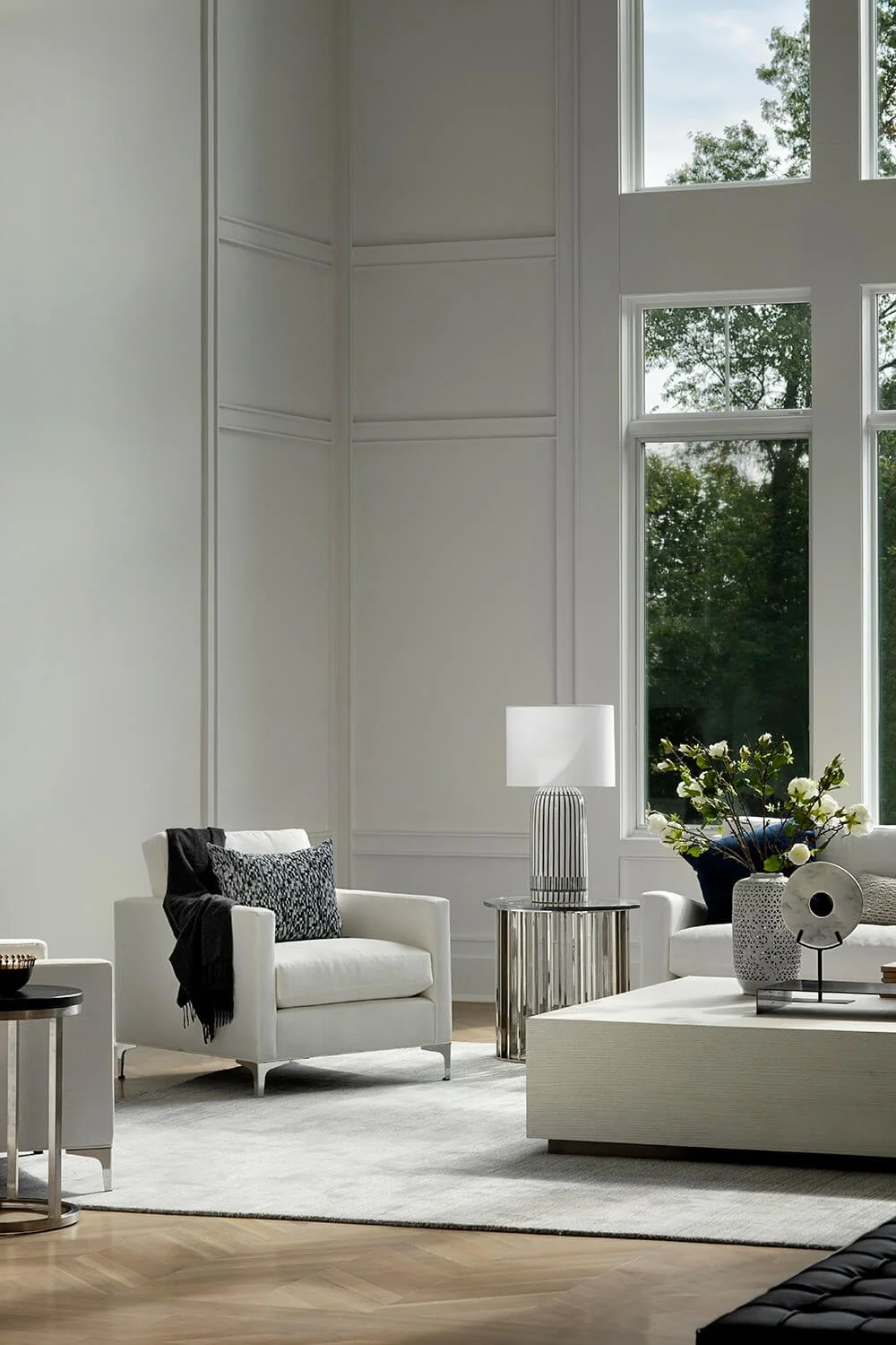 Dramatic living room with 30-foot ceilings, floor-to-ceiling windows, all-white decor, and modern furniture, photographed by Brian Berkowitz Photography in New York