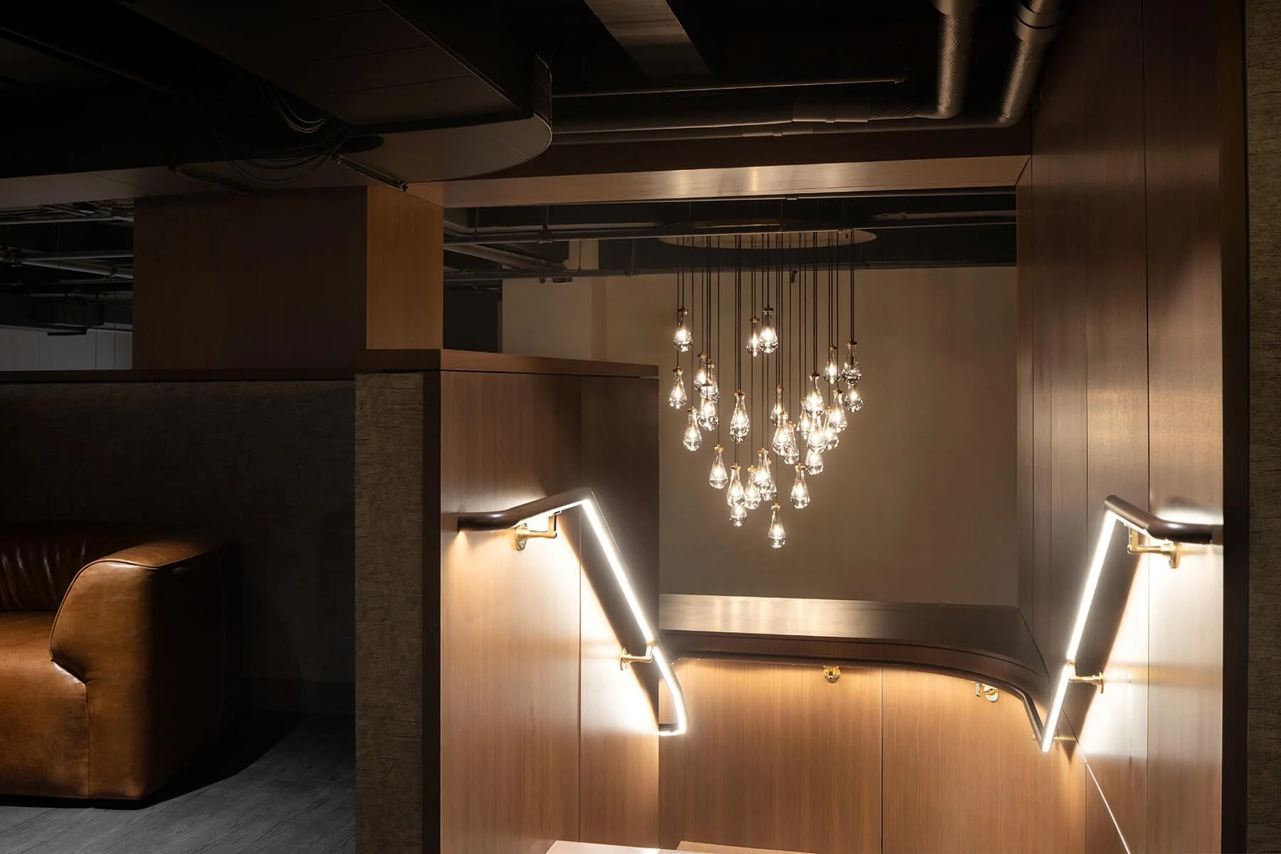 Overhead view of illuminated stairway and chandelier in TMPL Madison lobby