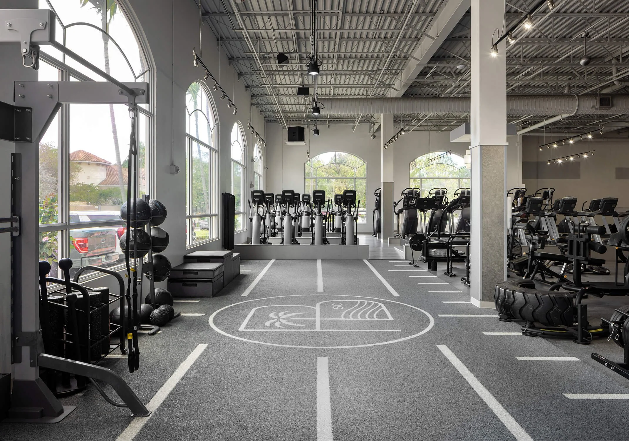 Bright wellness-focused fitness studio with cardio machines captured by Long Island Interior Design Photography.