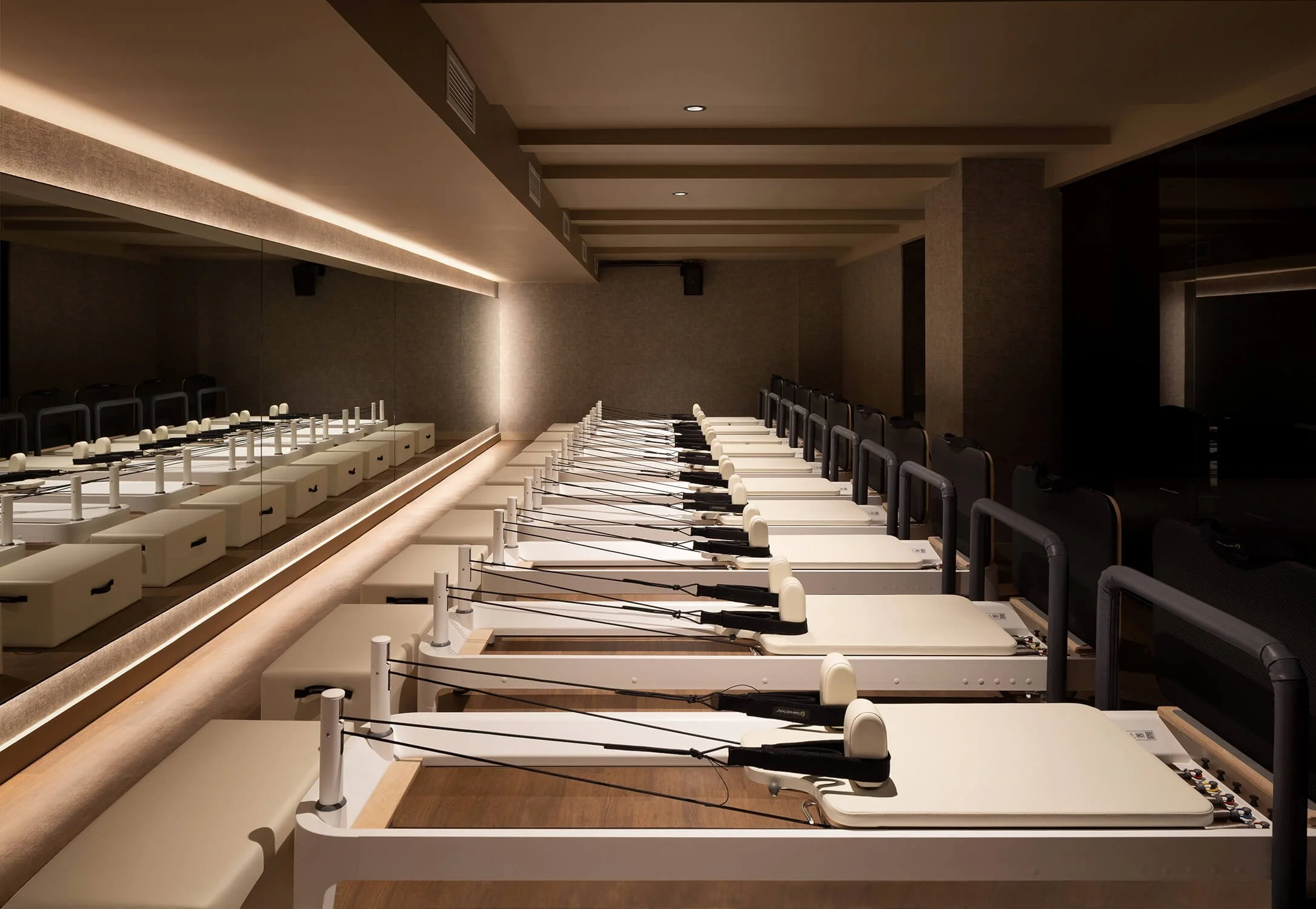 Wellness-focused Pilates studio with reformer machines by Interior Design Photographer NYC.