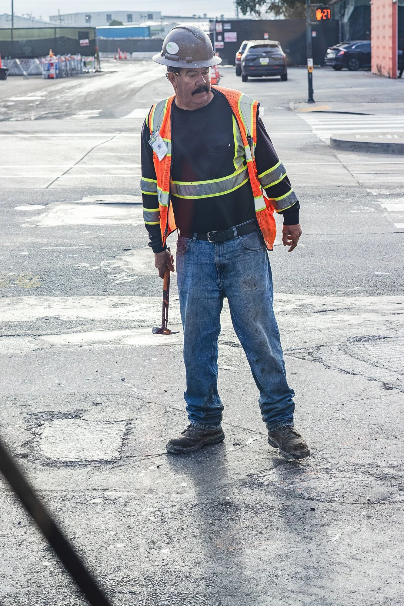 Man with hammer stands in front of the 9 bus. 
From 'Doors Are Opening' project, in progress. October 2026.