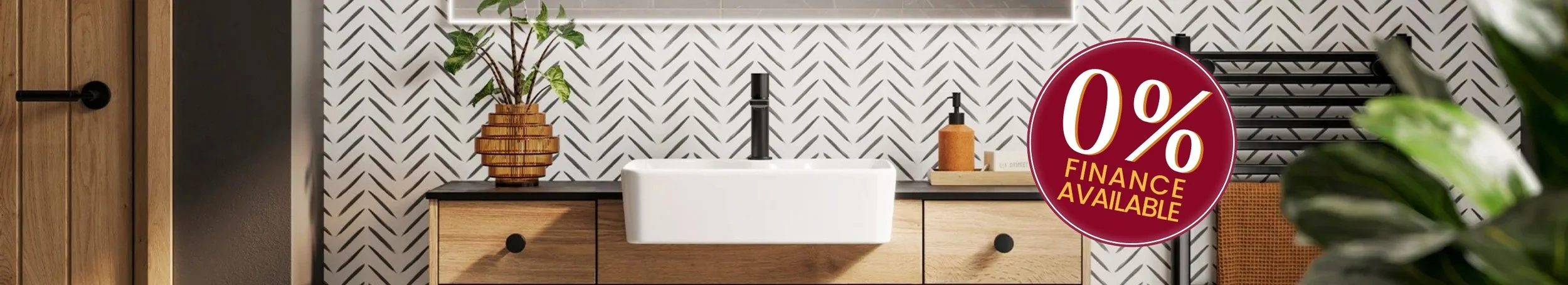 Modern bathroom with a patterned black and white tile wall, wooden vanity, white sink, black faucet, decorative wooden vase with green plant, black shelving, and a large round red sign offering 0% finance available.