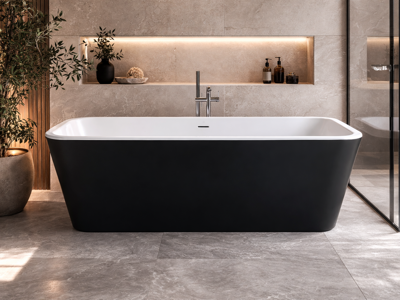 A modern bathroom features a black and white freestanding bathtub, with a beige tiled wall and a built-in shelf with decorative items and toiletries, sunlight casting shadows on a large potted plant to the left.