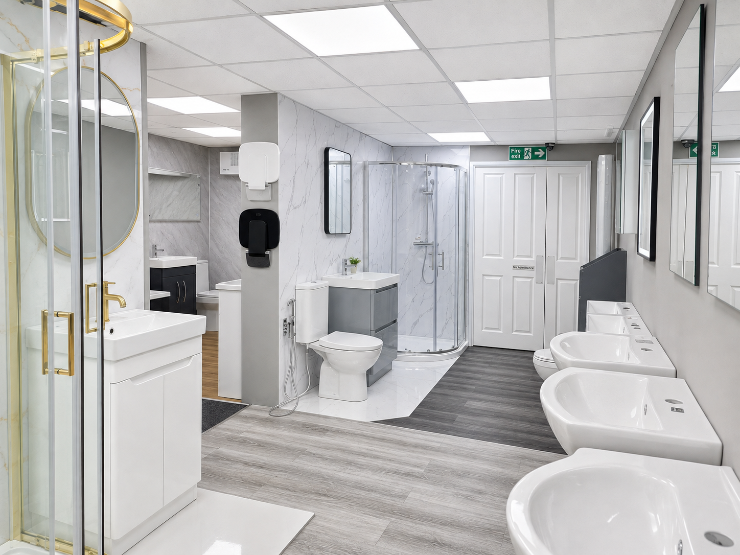 A modern public restroom with multiple sinks, mirrors, toilets, a shower stall, and hand sanitizer dispensers, with gray and white decor.