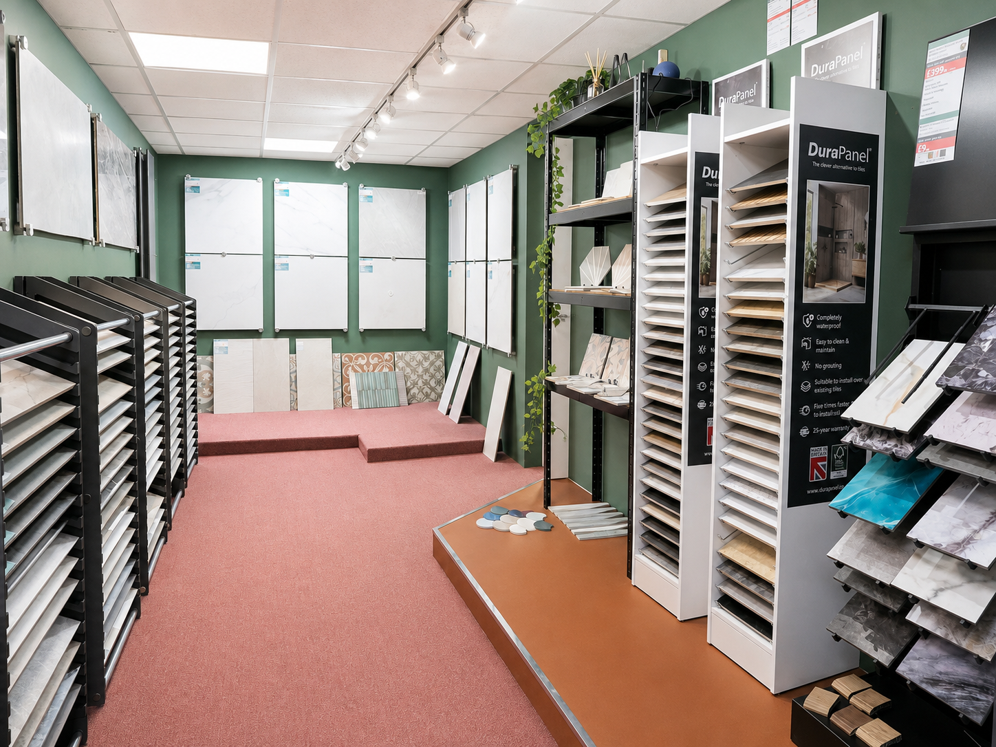 Showroom with wall displays of tiles and flooring samples, shelves with different textures and finishes, and small display platforms, in a retail store.
