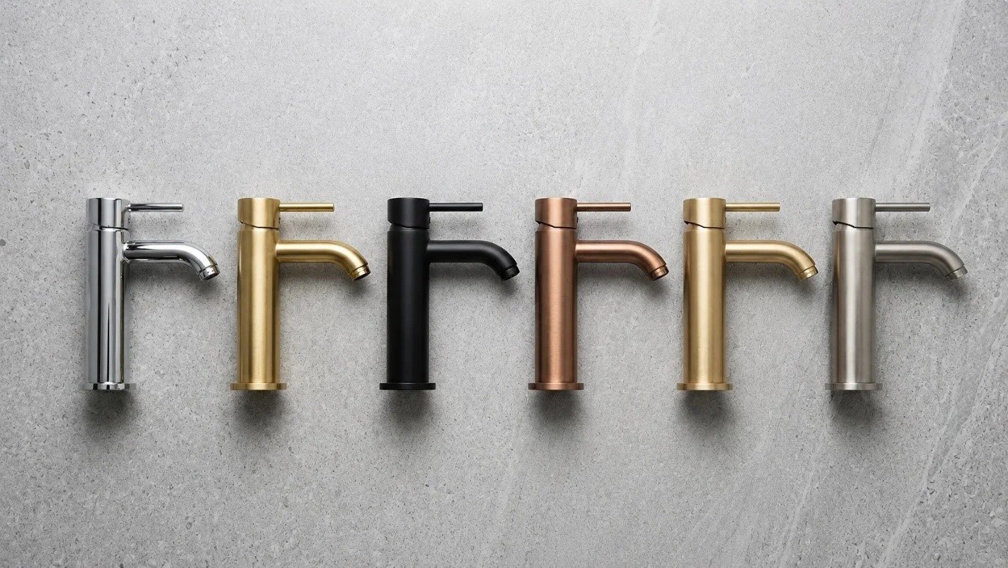 Six modern kitchen faucets in silver, gold, black, copper, brushed gold, and matte silver, arranged in a row against a light gray textured background.