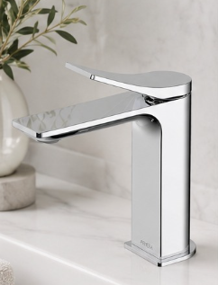 Modern chrome kitchen faucet on a white sink with a plant in the background.