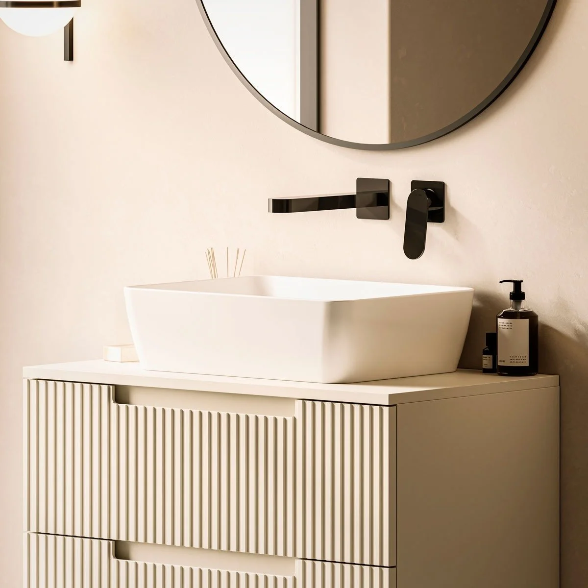 Modern bathroom vanity with a white vessel sink, black wall-mounted faucet, round mirror, and black soap dispenser. Stylish vanity units and bathroom furniture on display at Island Bathrooms Bournemouth