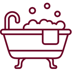 Bathtub with bubbles and a towel hanging over the side