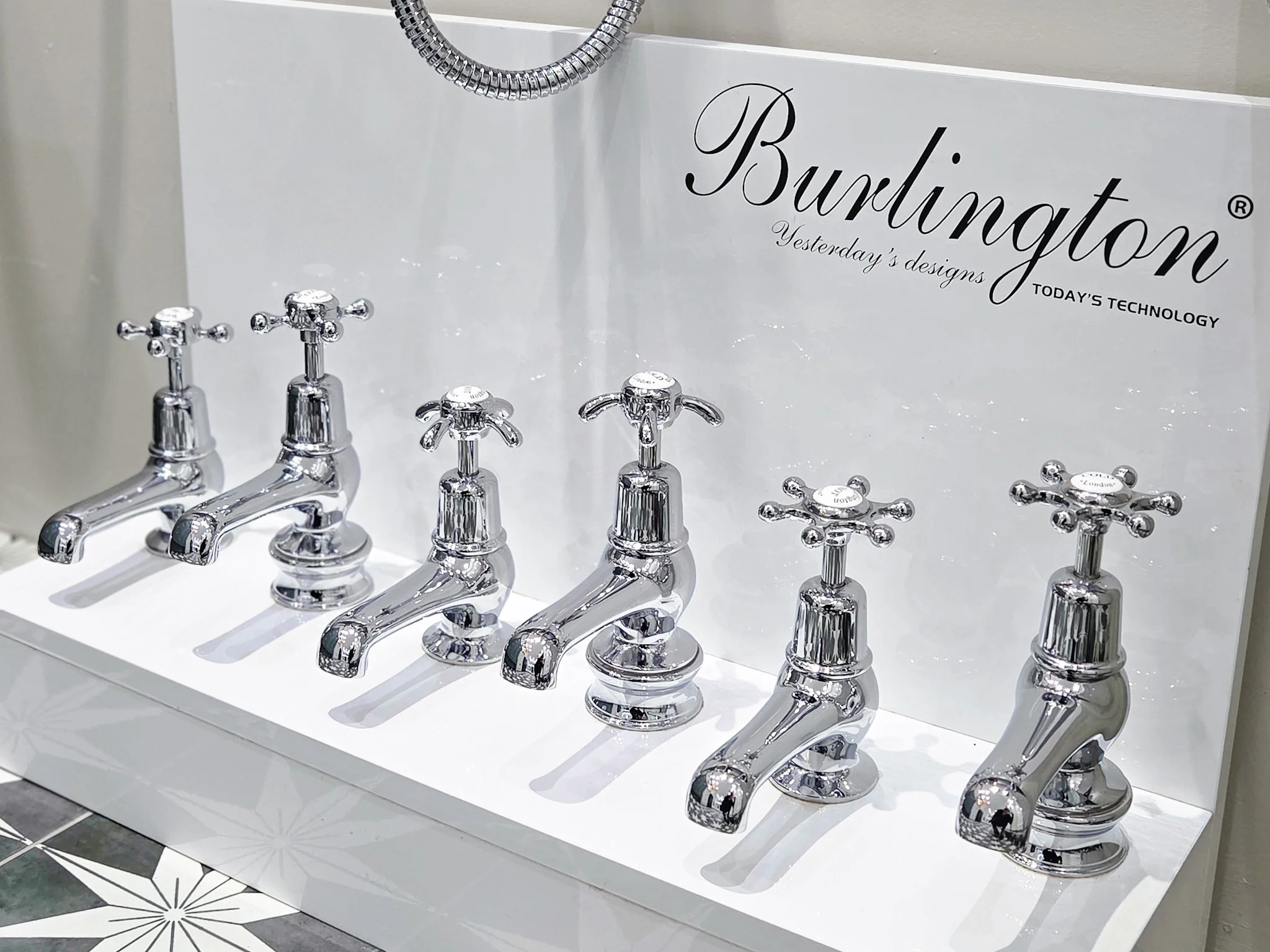 Display of modern chrome bathroom sink faucets with the brand name 'Burchington' and the slogan 'Yesterday's designs, Today's technology' on a white backdrop.