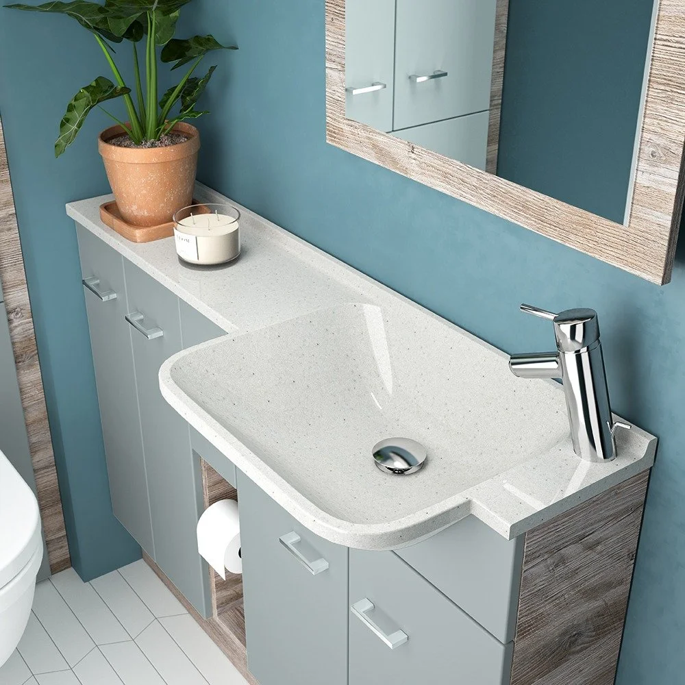 Bathroom vanity with a white countertop, and a mirror with a wooden frame, against blue walls. Fitted bathroom cabinets and vanity units on display in Salisbury Wiltshire