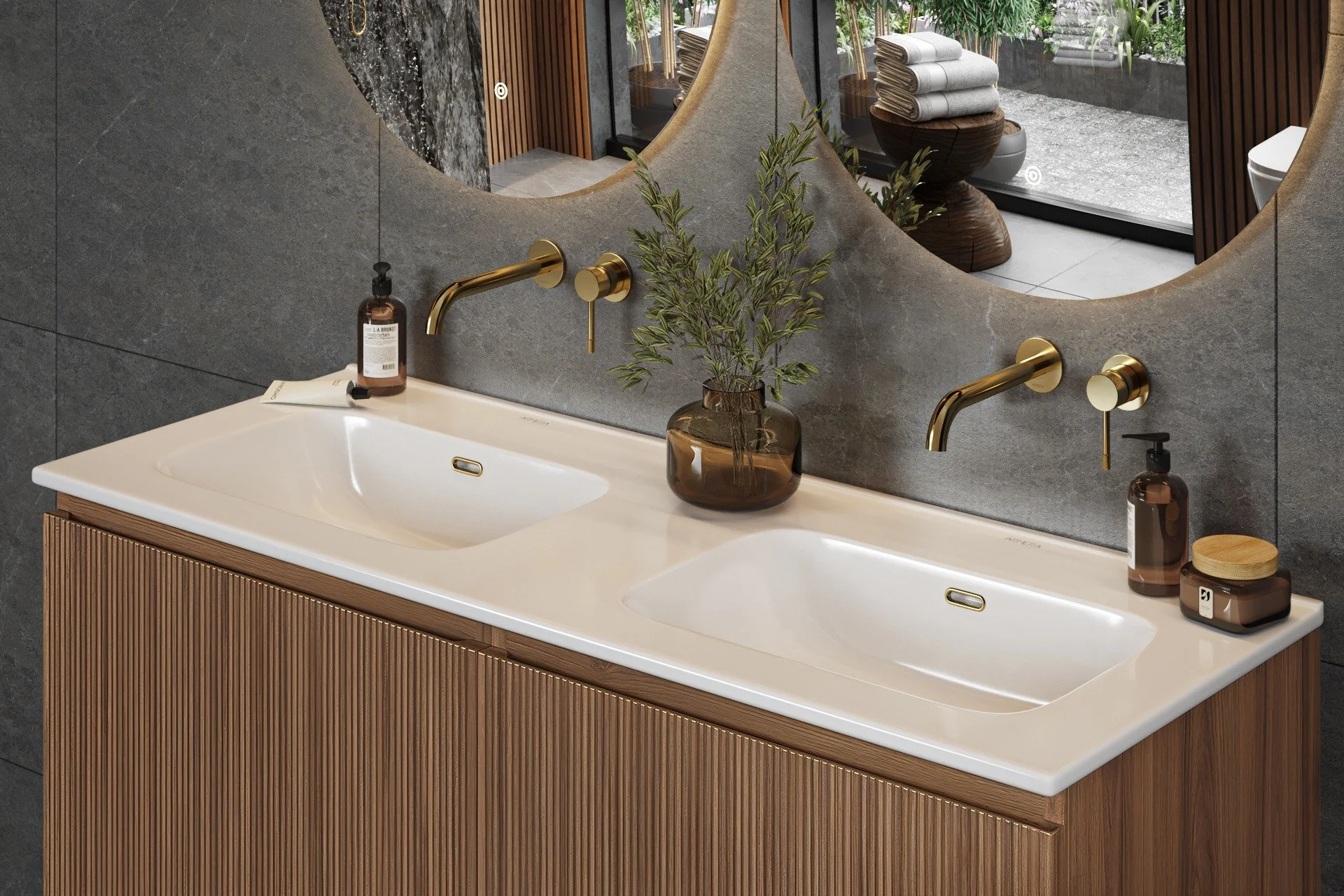 Contemporary bathroom vanity with a double sink, gold faucets, and a large mirror. The wall behind is covered with dark textured tiles - all items available in Island Bathrooms showroom in Dorset and Wiltshire
