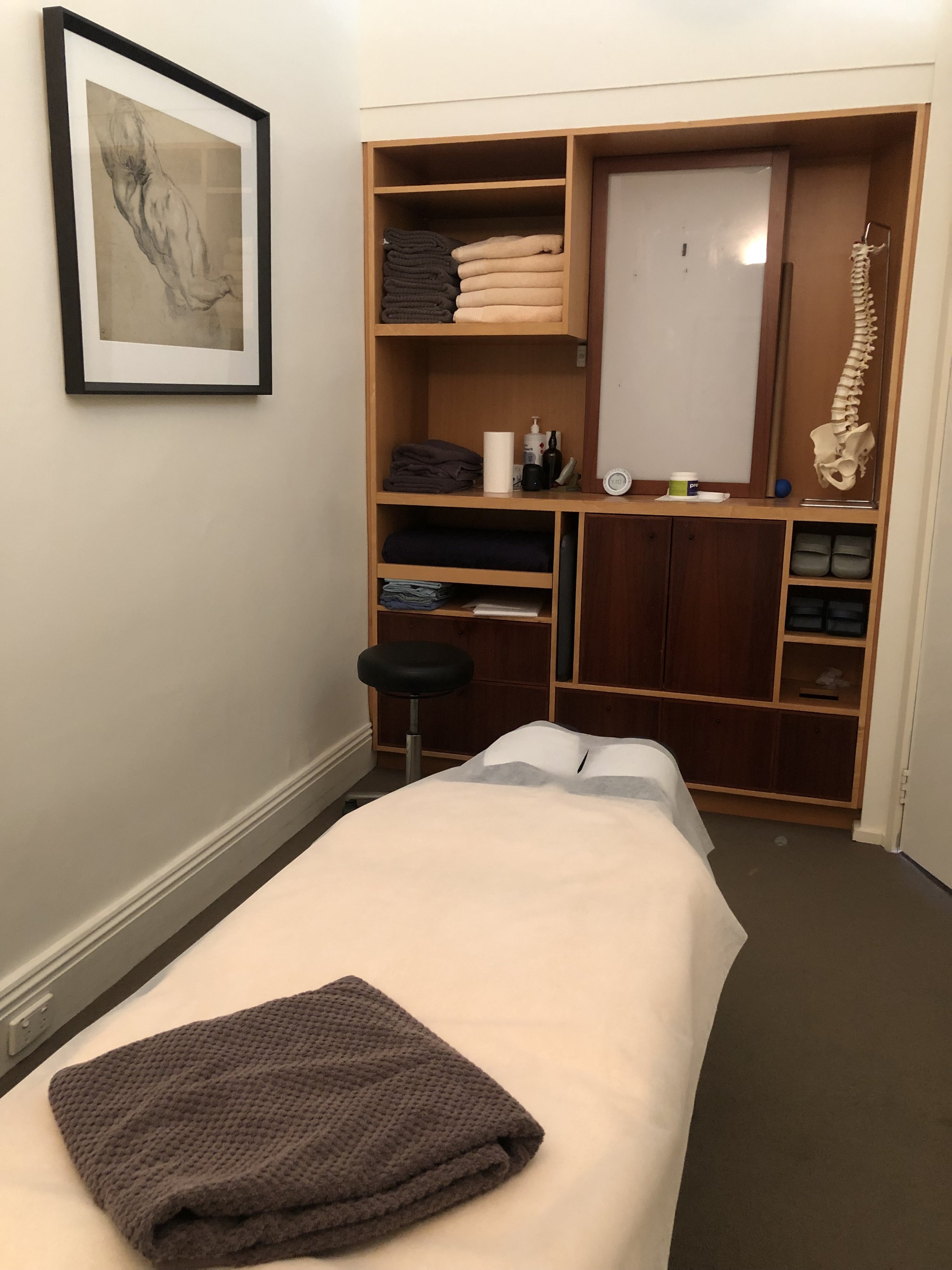 A chiropractic treatment room with a model of the human spine