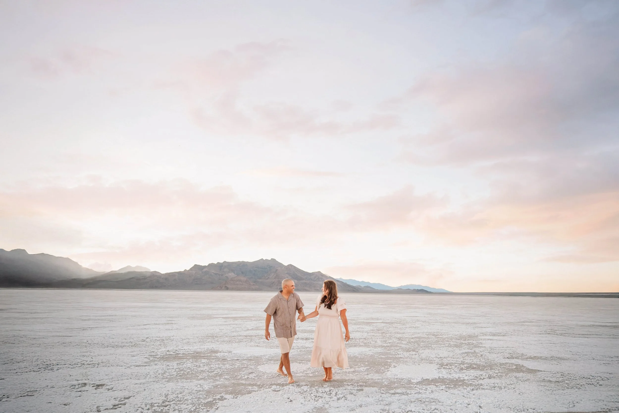 Couple looking at each other walking across the Bonneville Salt Flats in Utah.
