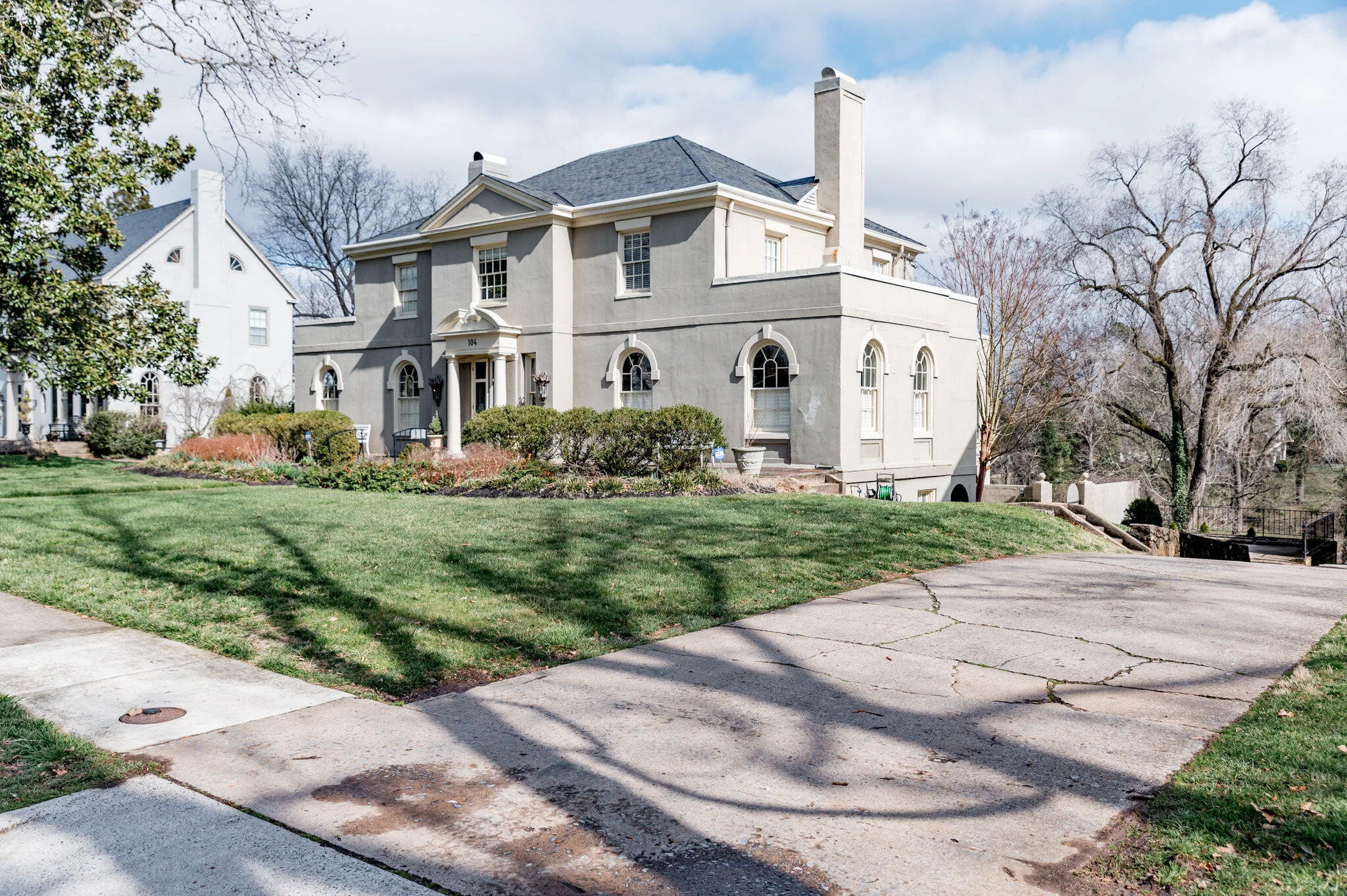 Large traditional house with a manicured lawn and driveway
