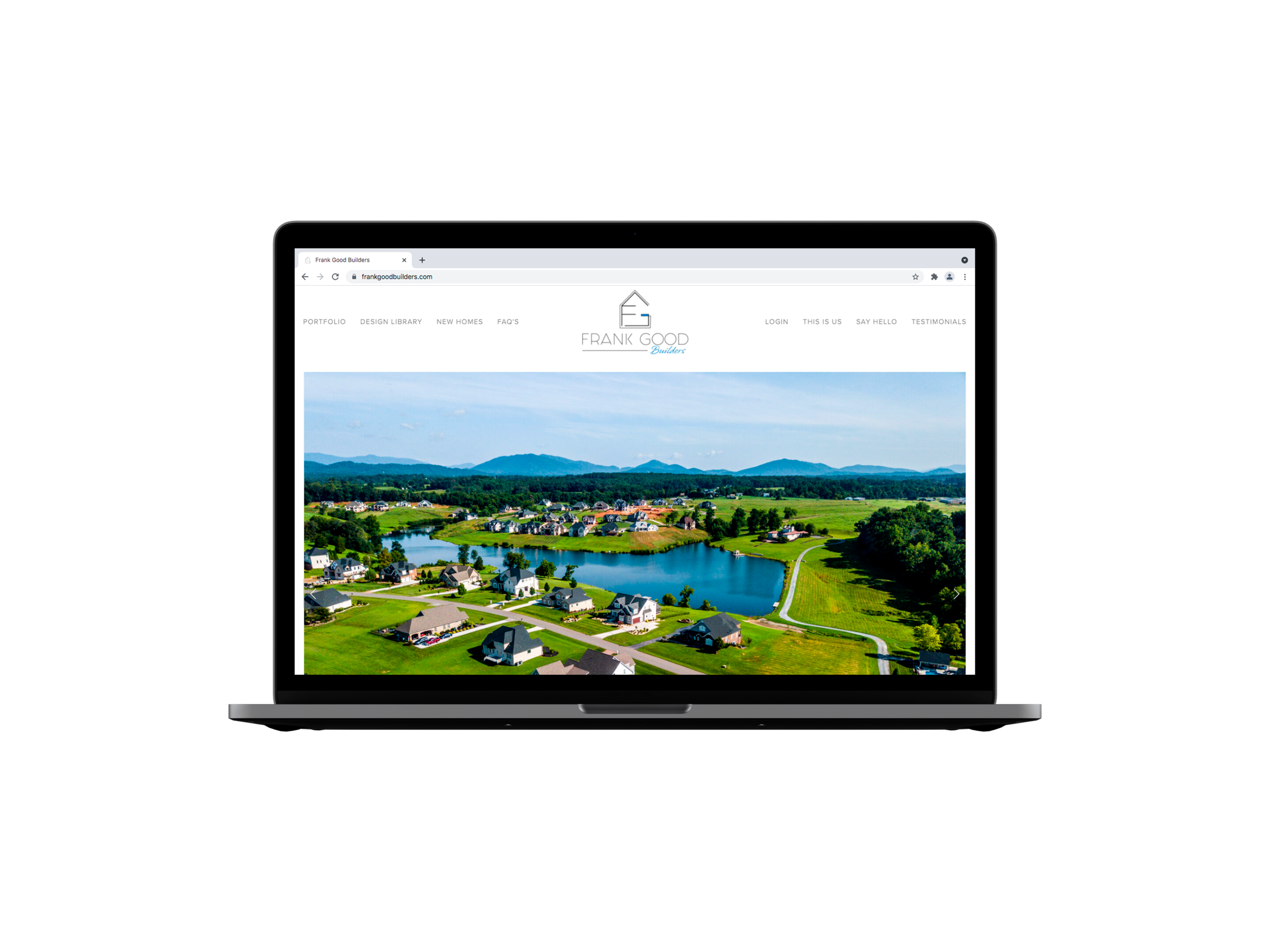 Laptop displaying a real estate website with a scenic aerial view of a residential neighborhood near a lake and green landscape.