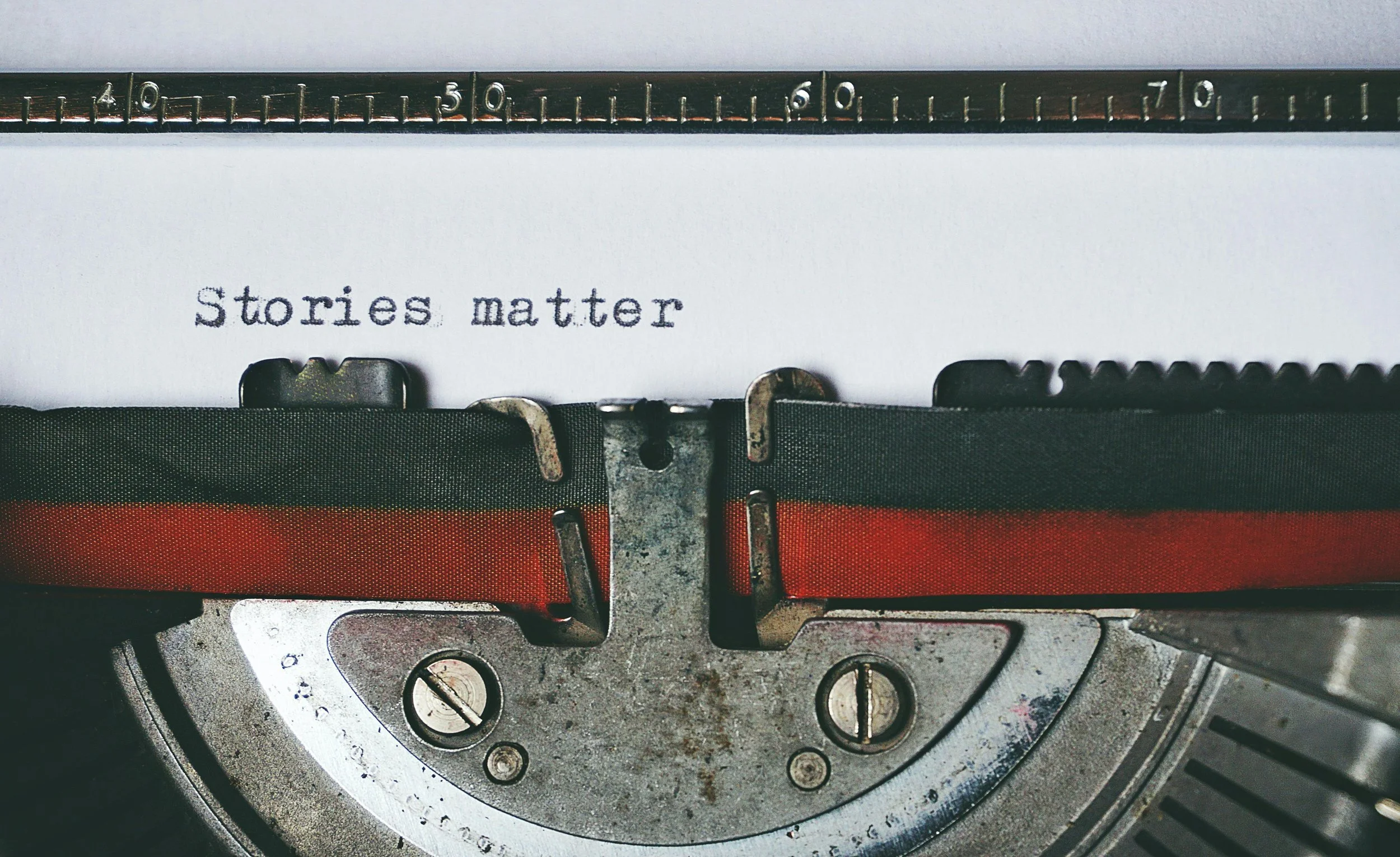 Close-up of a vintage typewriter with a paper insert displaying the words 'Stories matter' in typewriter font.