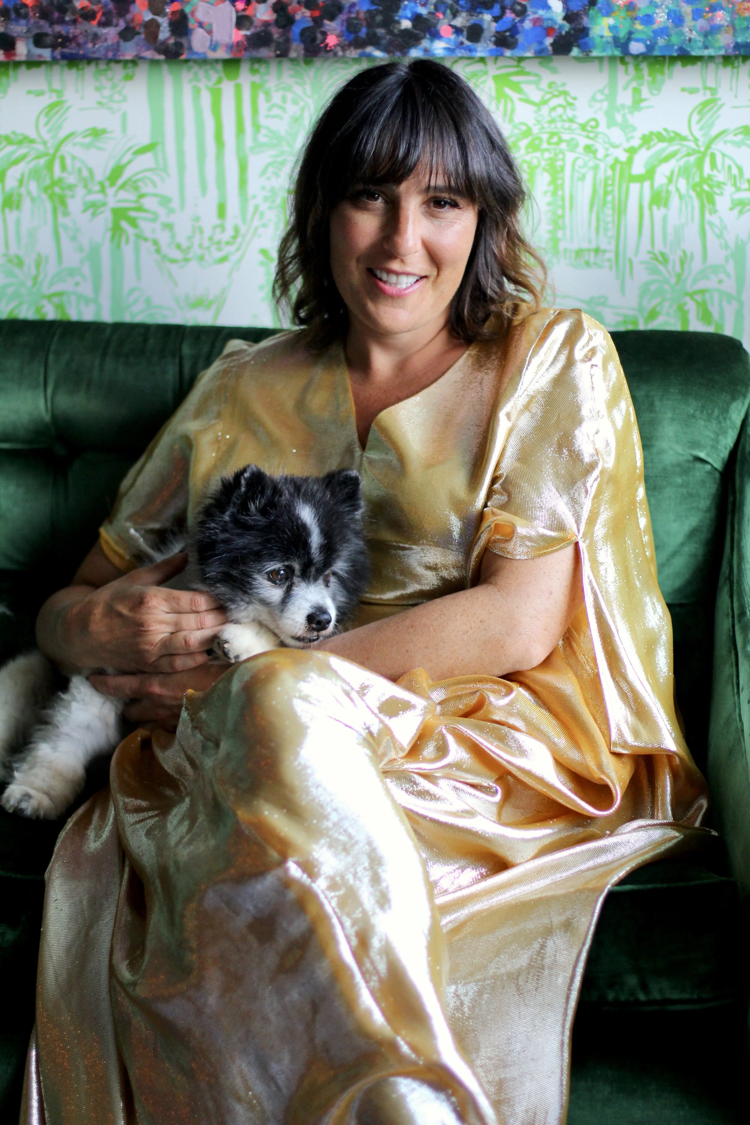 Melanie and her fabulous, neurotic little dog sitting together on a green velvet sofa