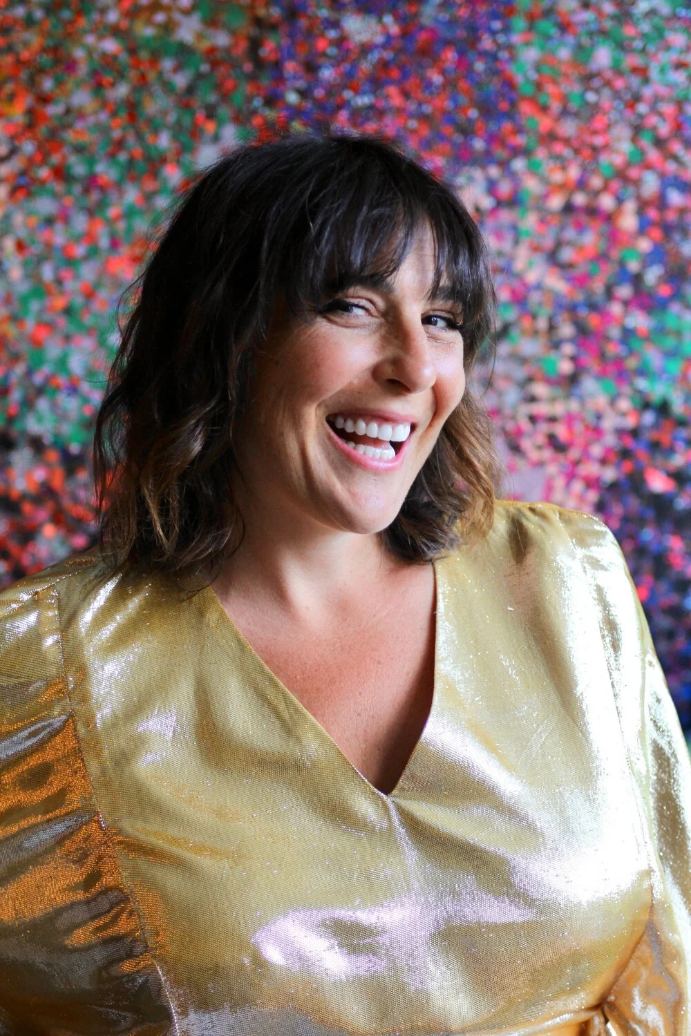 Melanie Greenberg, performer and creator, in a badass gold dress