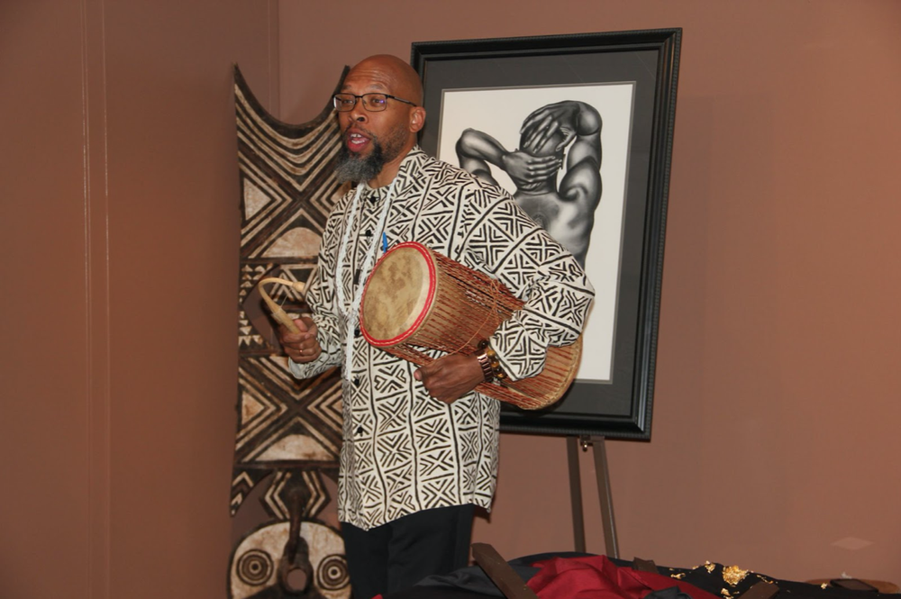 Dr. Akil Khalfani holding a drum in the Africana Institute, June 15, Newark, NJ. (Photo courtesy of Evans Mensah)
