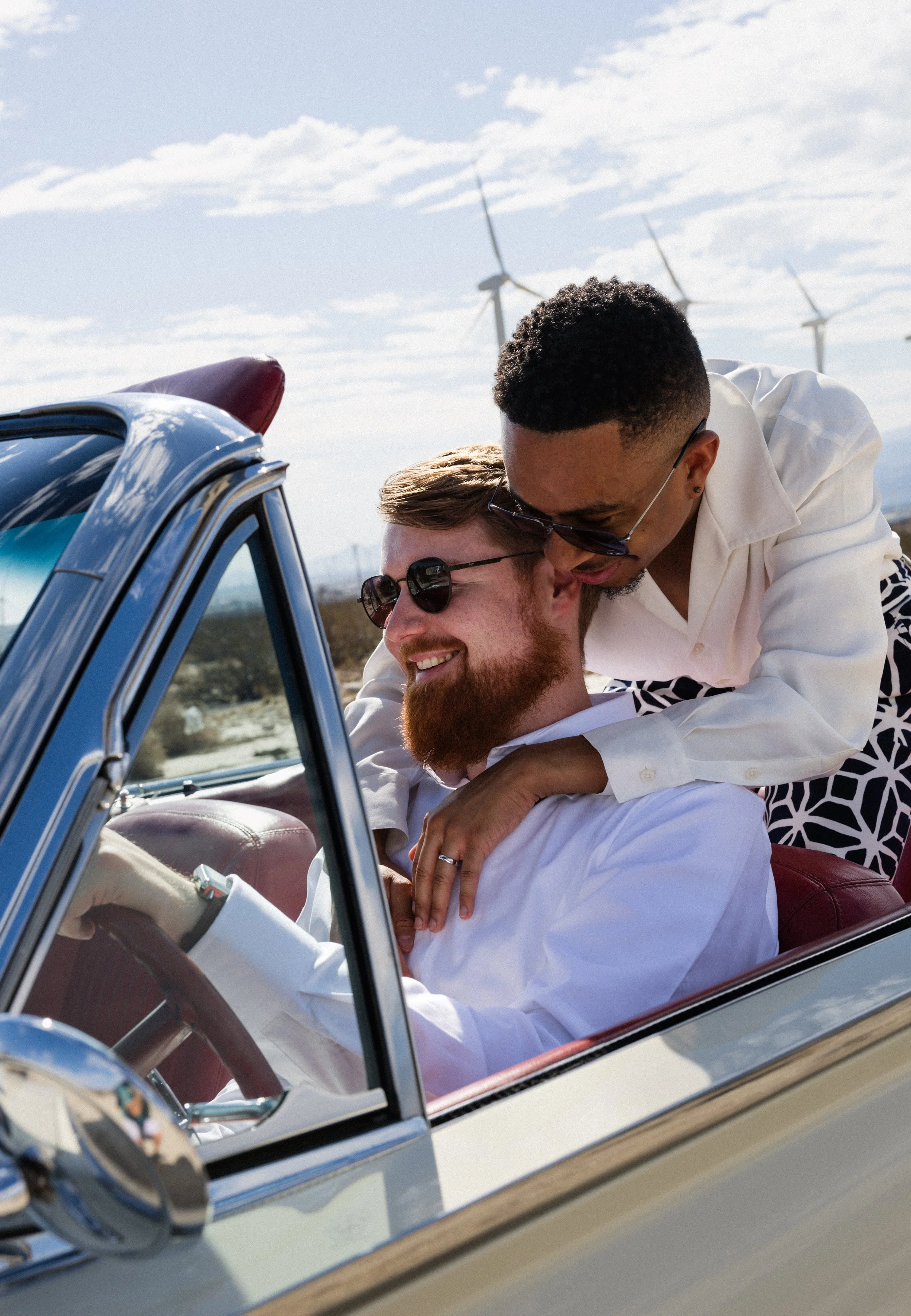 palm springs gay elopement- couple wearing sunglasses driving a vintage car
