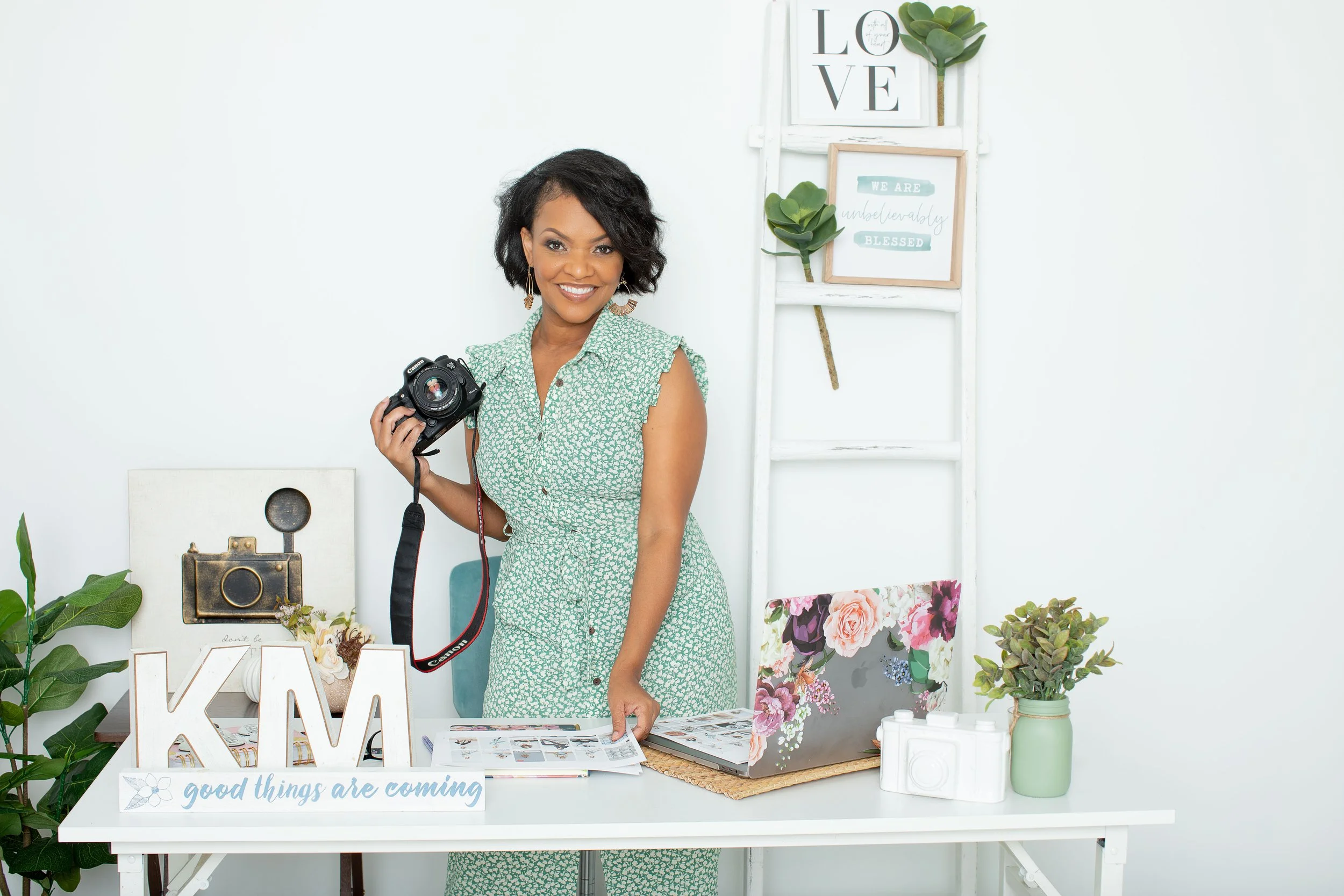 Atlanta family photographer Kizzy Michelle smiling in studio holding camera