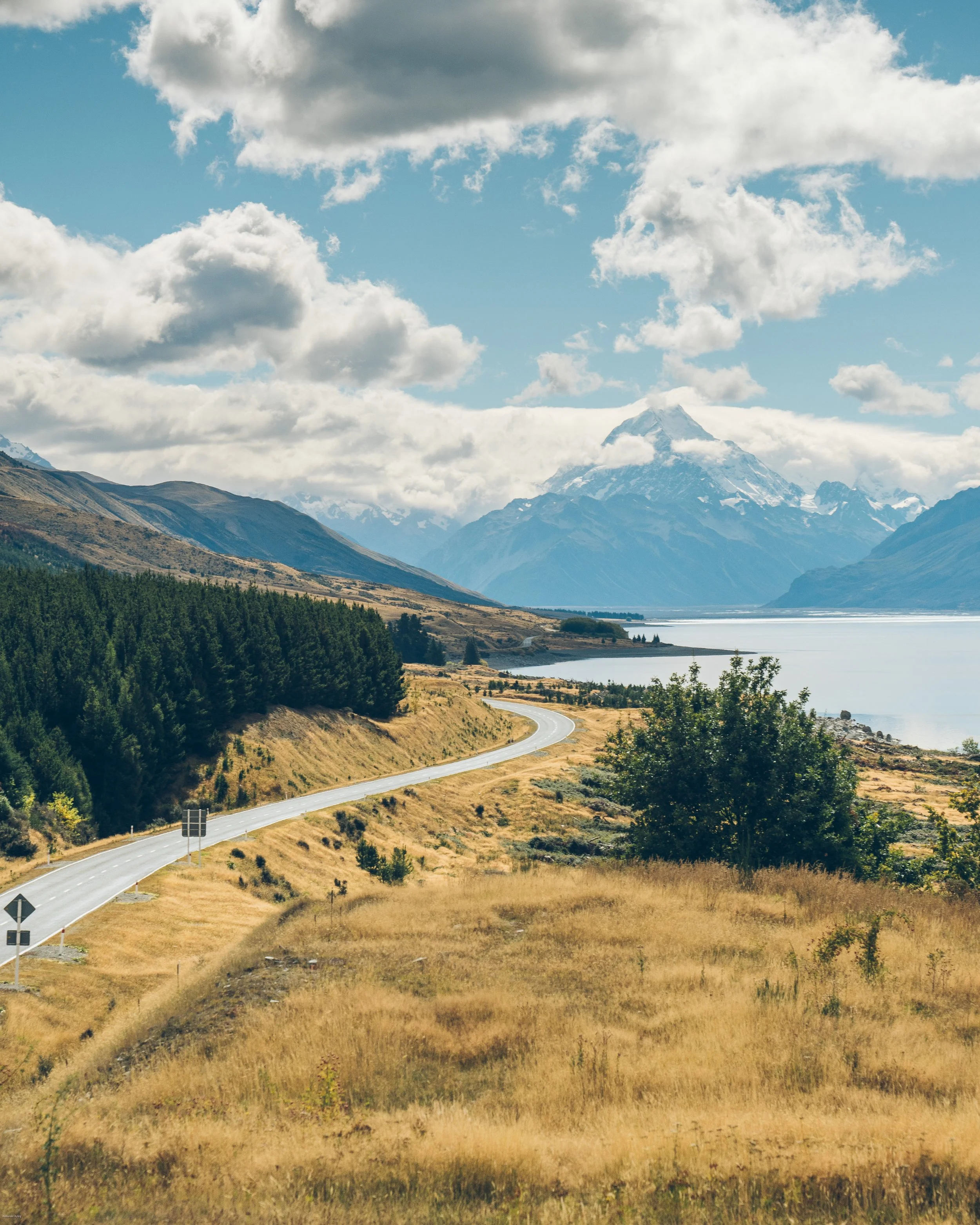 Scenic drive beside the turquoise waters of Lake Pukaki with Aoraki / Mount Cook rising in the distance, one of New Zealand's most iconic road trip views on the South Island.