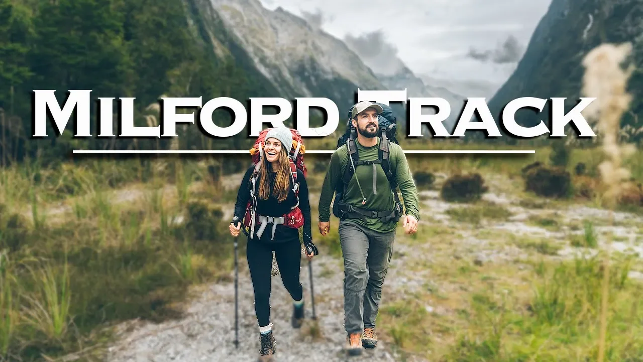 Alexander Ayling and Carrie Rad hiking the Milford Track with backpacks through the dramatic mountains and glacial valleys of Fiordland National Park, New Zealand.