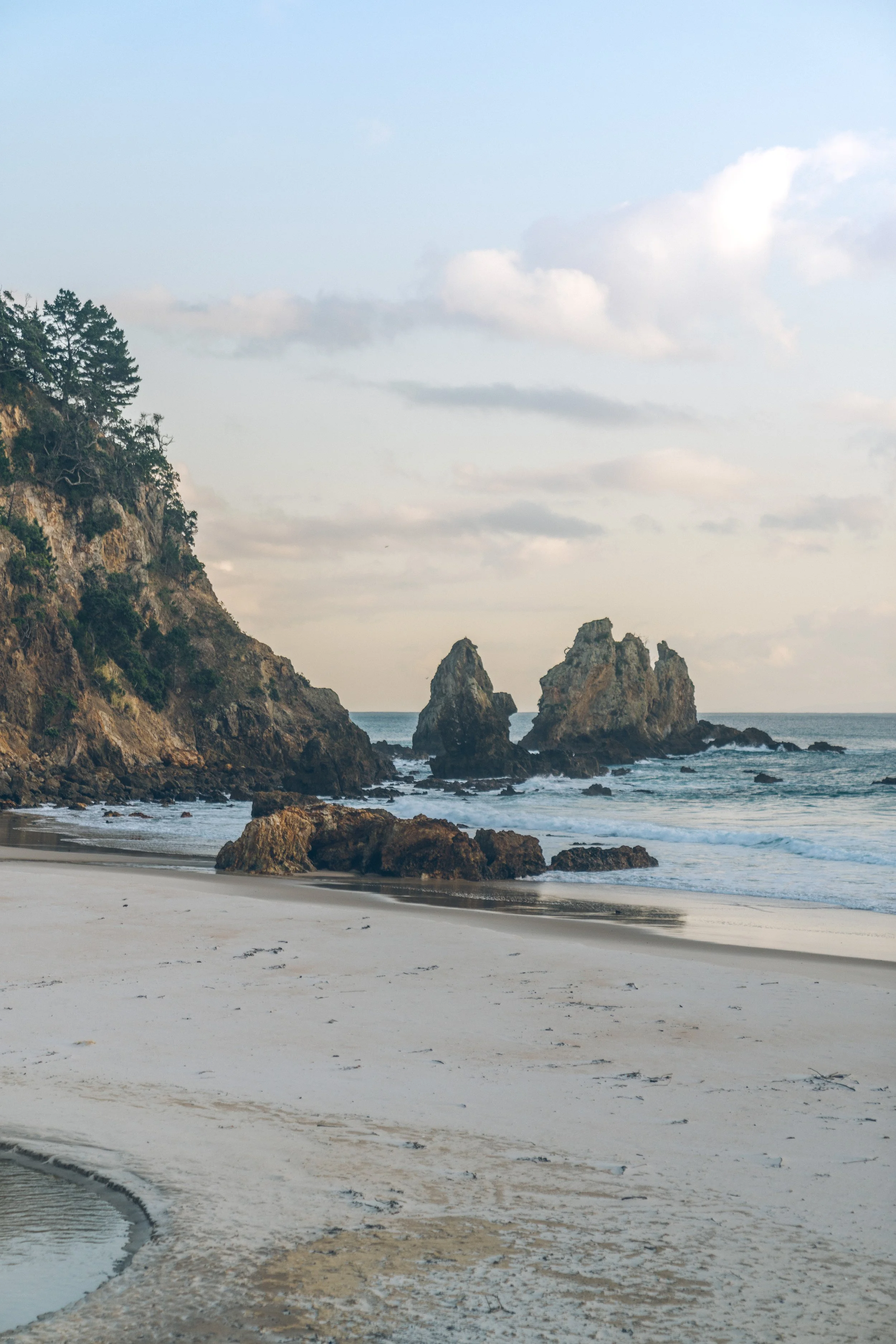 Sunrise over a secluded beach near Cathedral Cove and the Coromandel Coastal Walkway, with dramatic sea stacks along the Coromandel Peninsula, North Island, New Zealand.