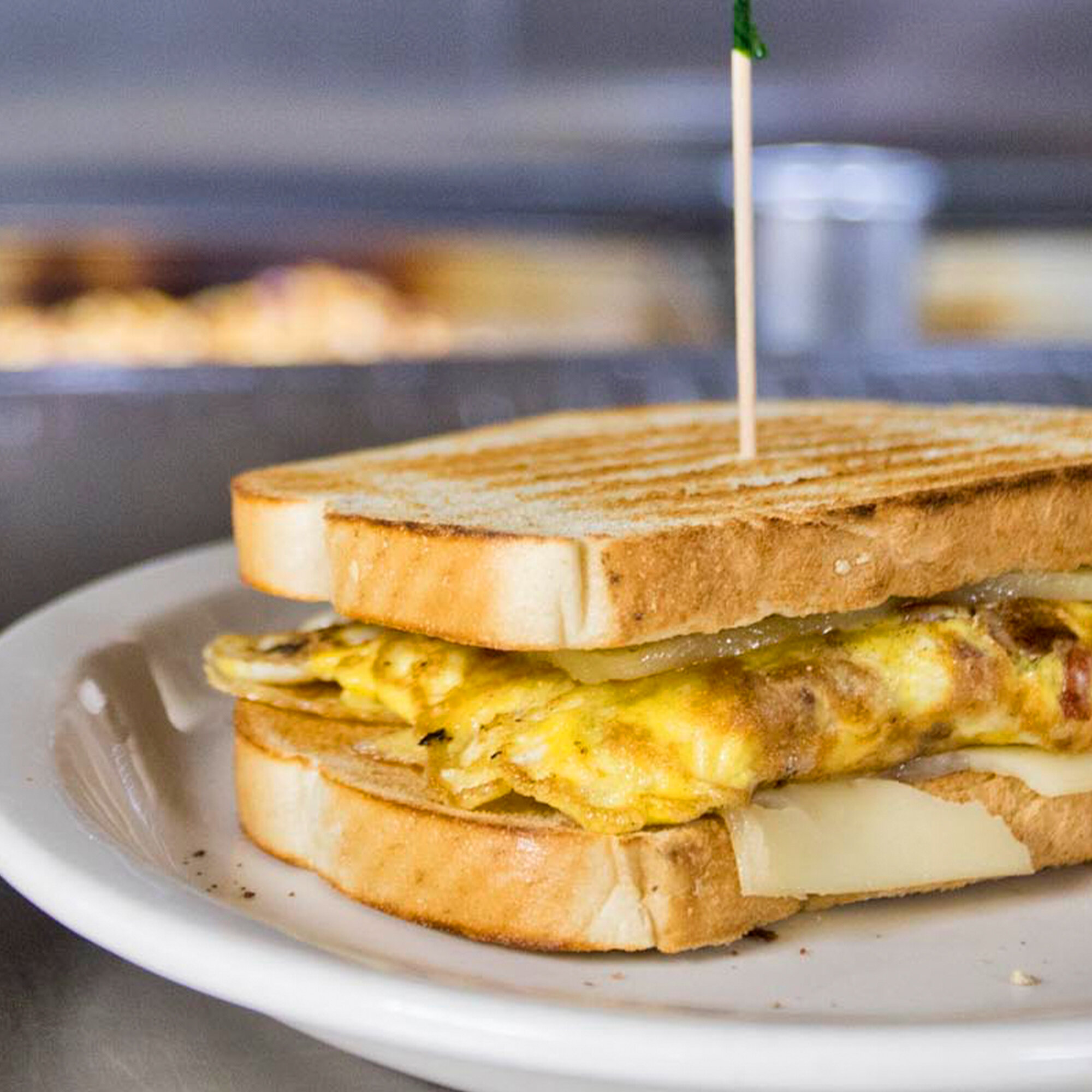  grilled egg and cheese breakfast sandwich on a plate 
