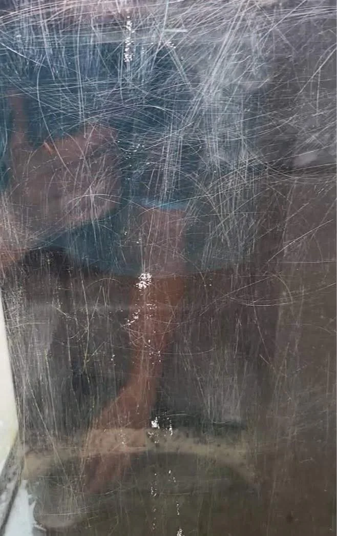 Severely scartched glass surface with deep scratch patterns prior to restoration.