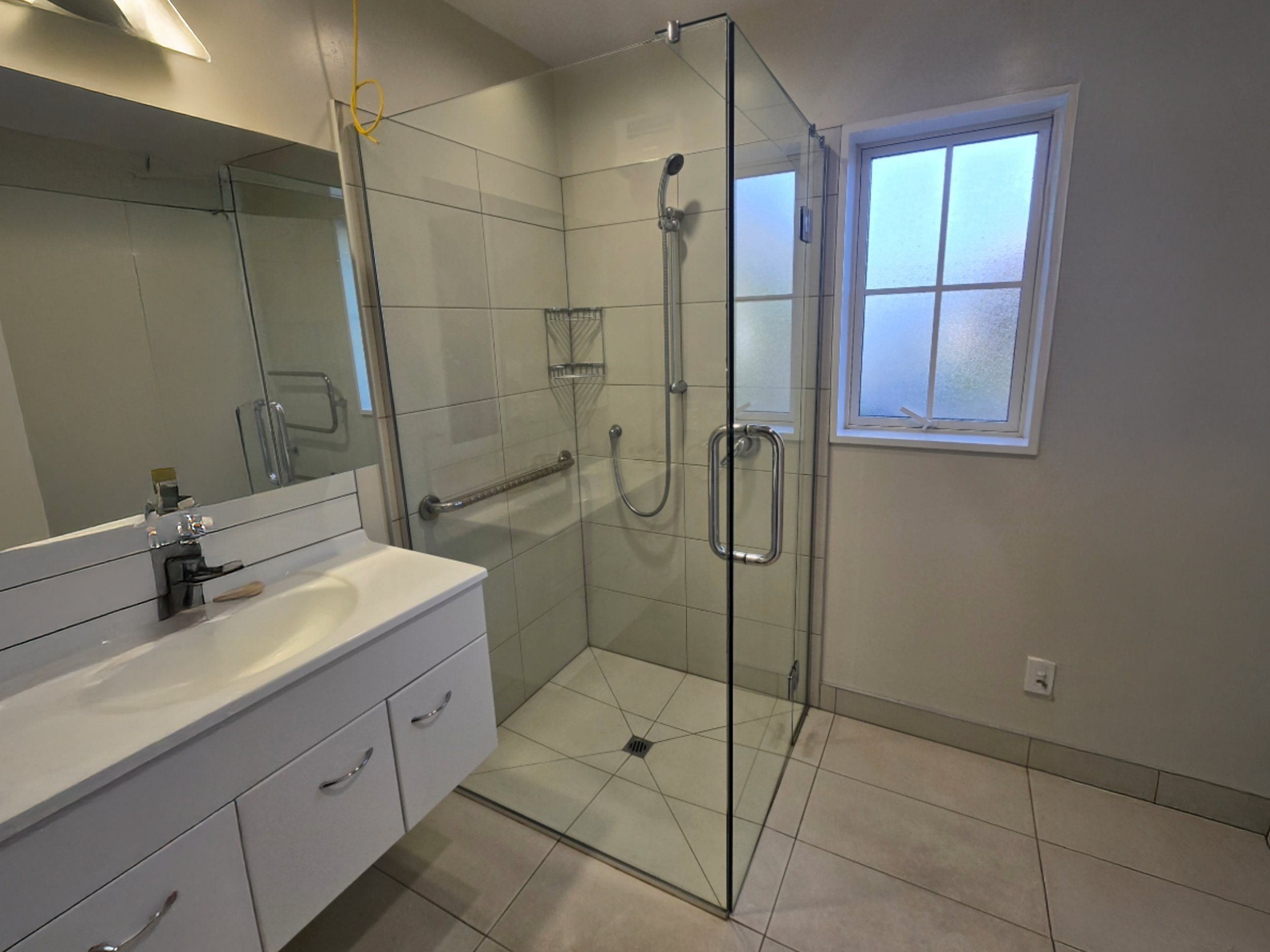 Custom frameless glass shower showing full layout with multiple glass panels
