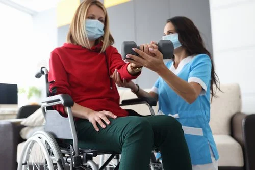 NDIS physiotherapy session – physiotherapist assisting patient with mobility and strength exercises