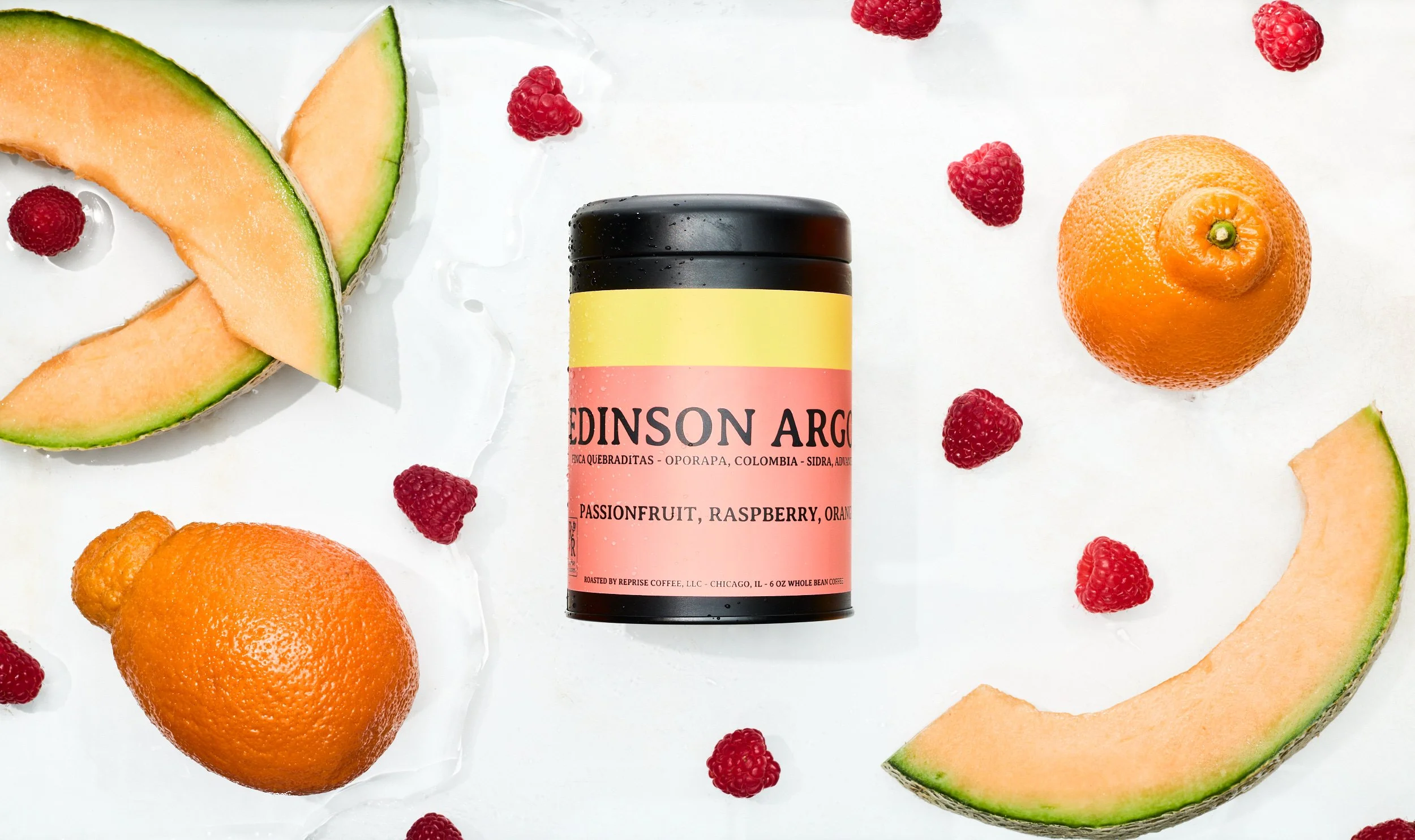 A canister labeled 'EDINSON ARGO' surrounded by slices of cantaloupe, whole orange, small oranges, and fresh raspberries on a white surface.