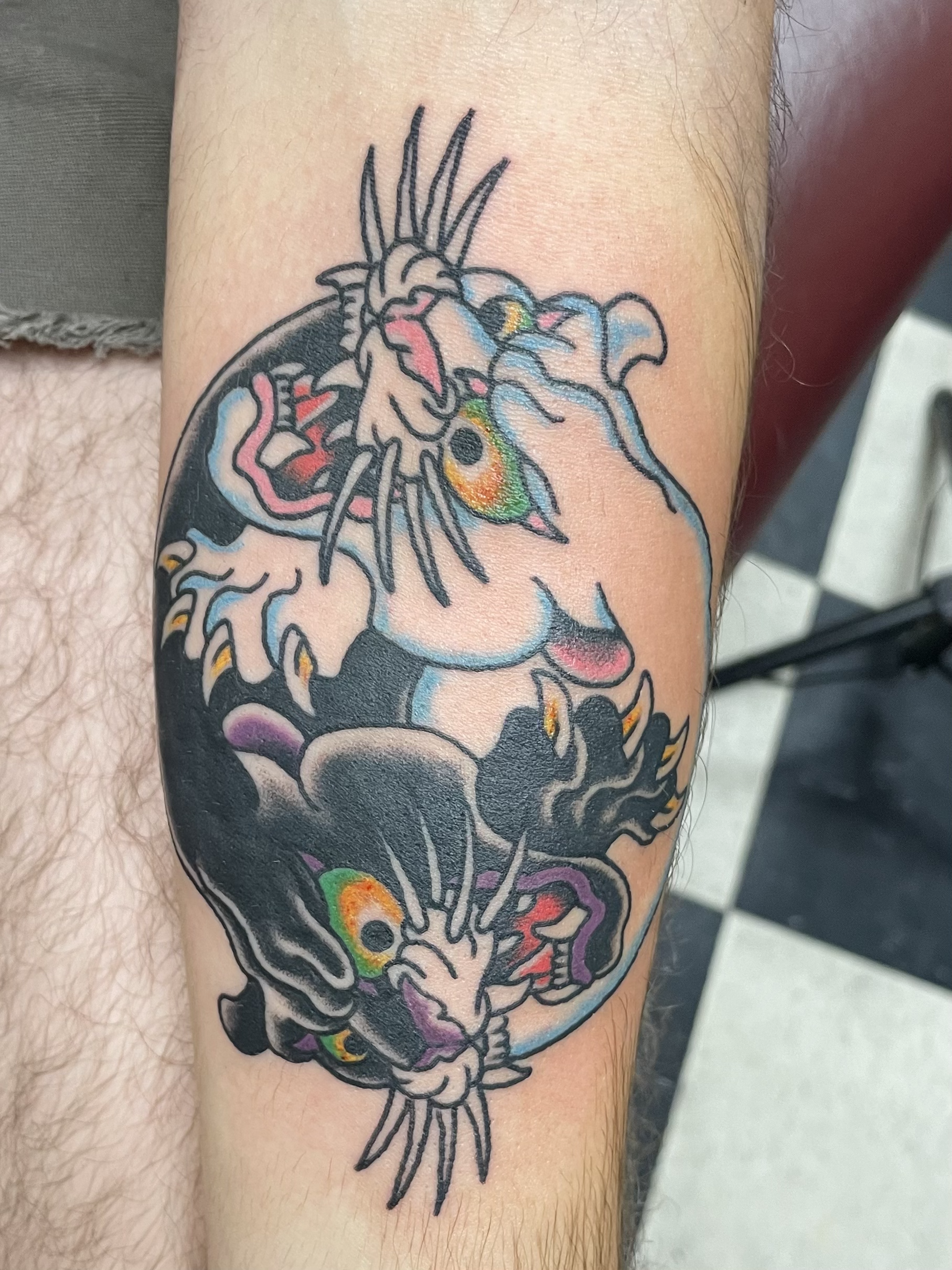 Colorful tattoo of a unicorn with rainbow accents on a person's arm.
